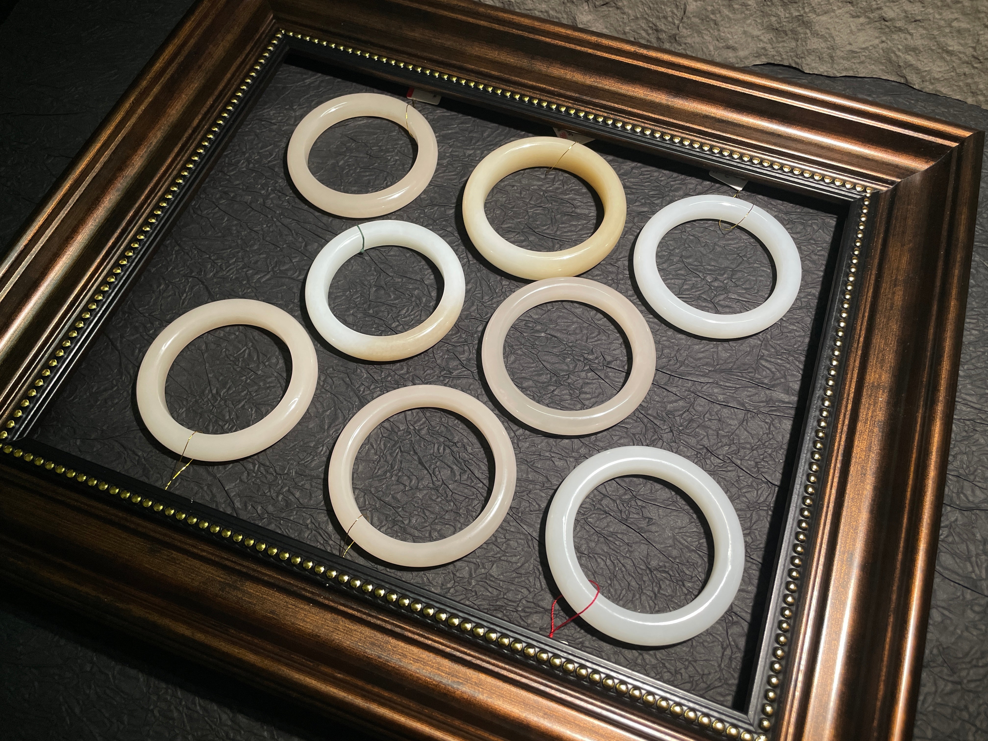 Set of white rings displayed in a decorative frame on a dark surface