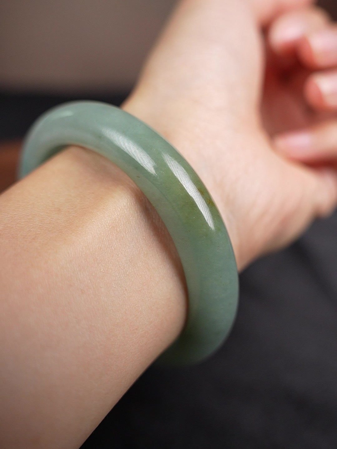 Pale green Type A jadeite bangle worn on wrist, angle 1