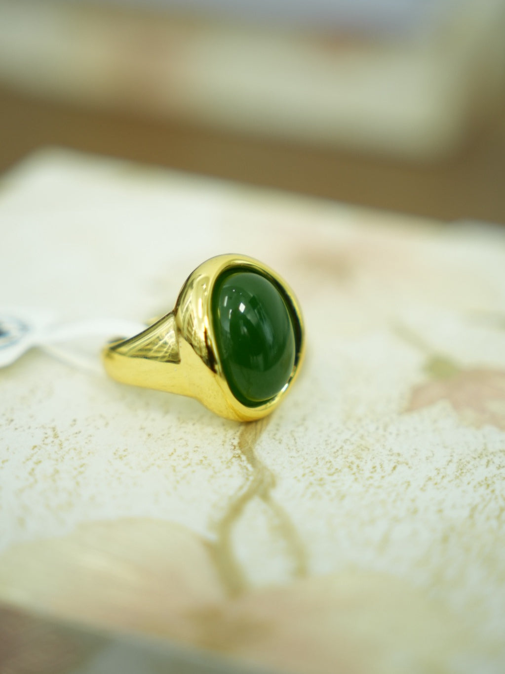 Green Hetian nephrite jade ring in a silver setting with a gold-tone appearance