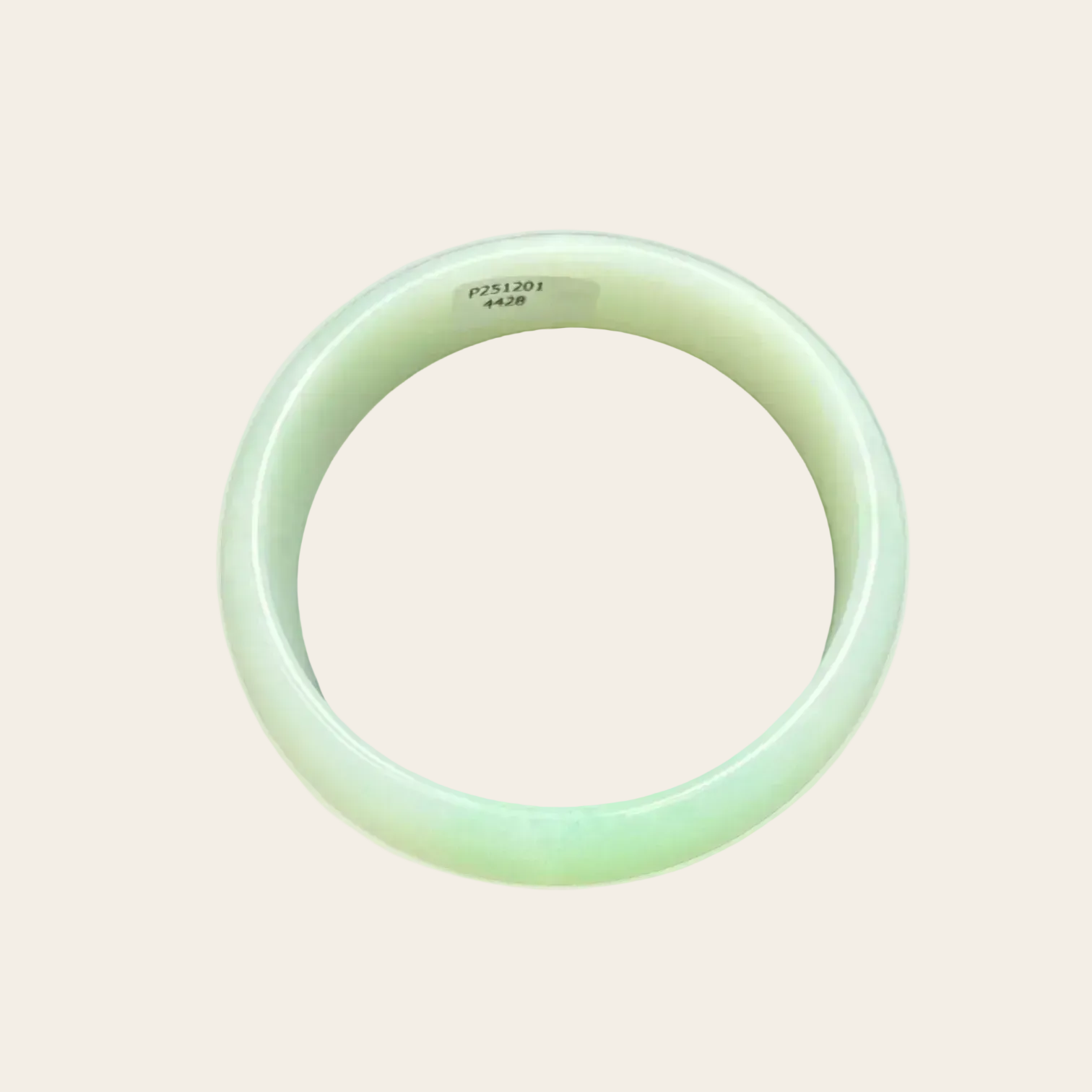 Green jade bracelet on a light beige background