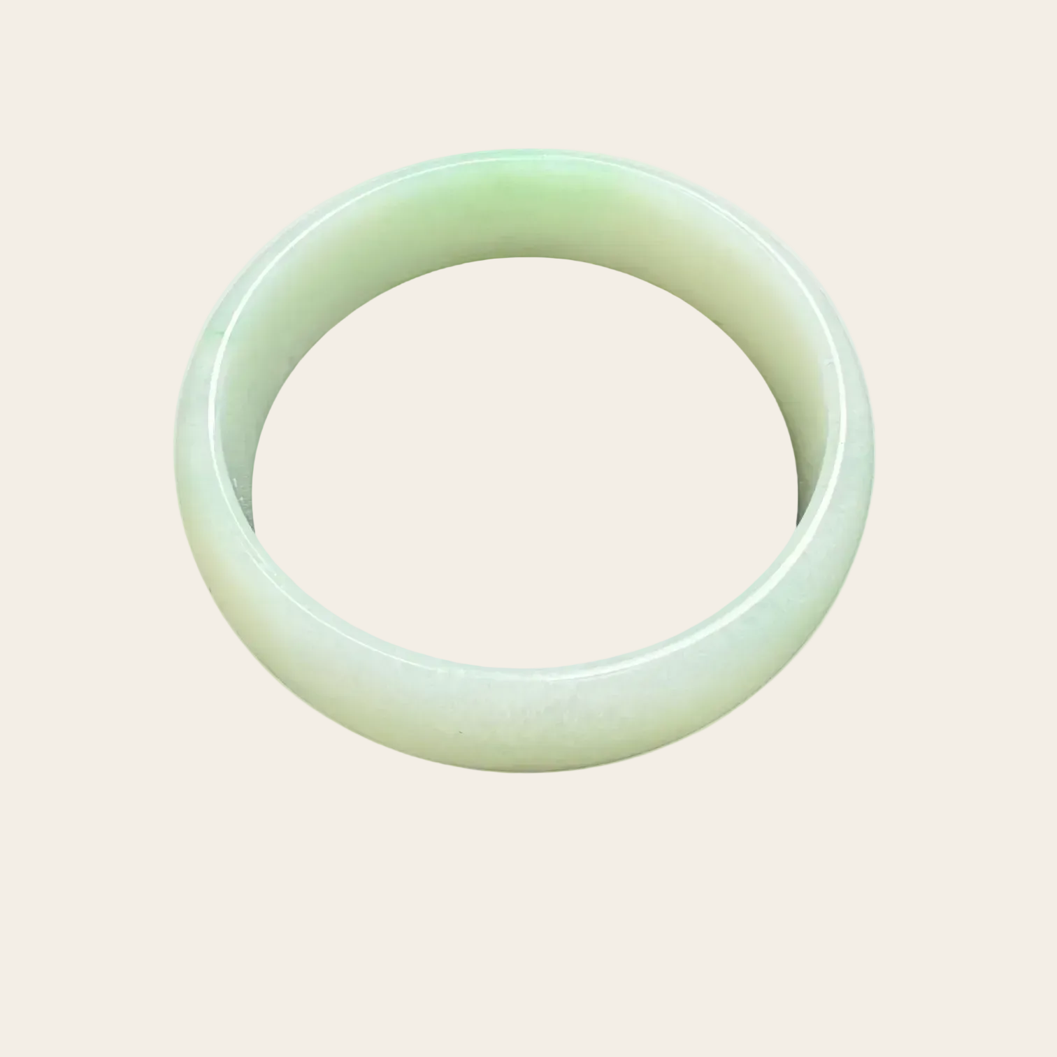 Green jade bracelet on a light beige background