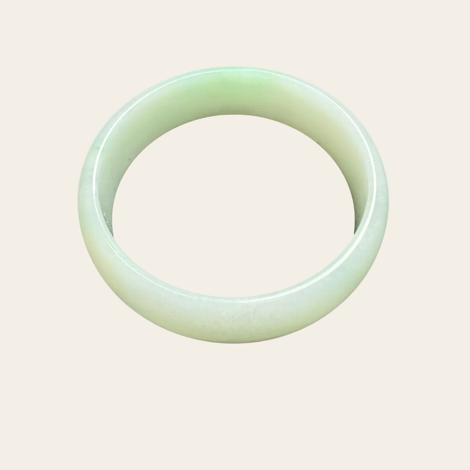 Green jade bracelet on a light beige background