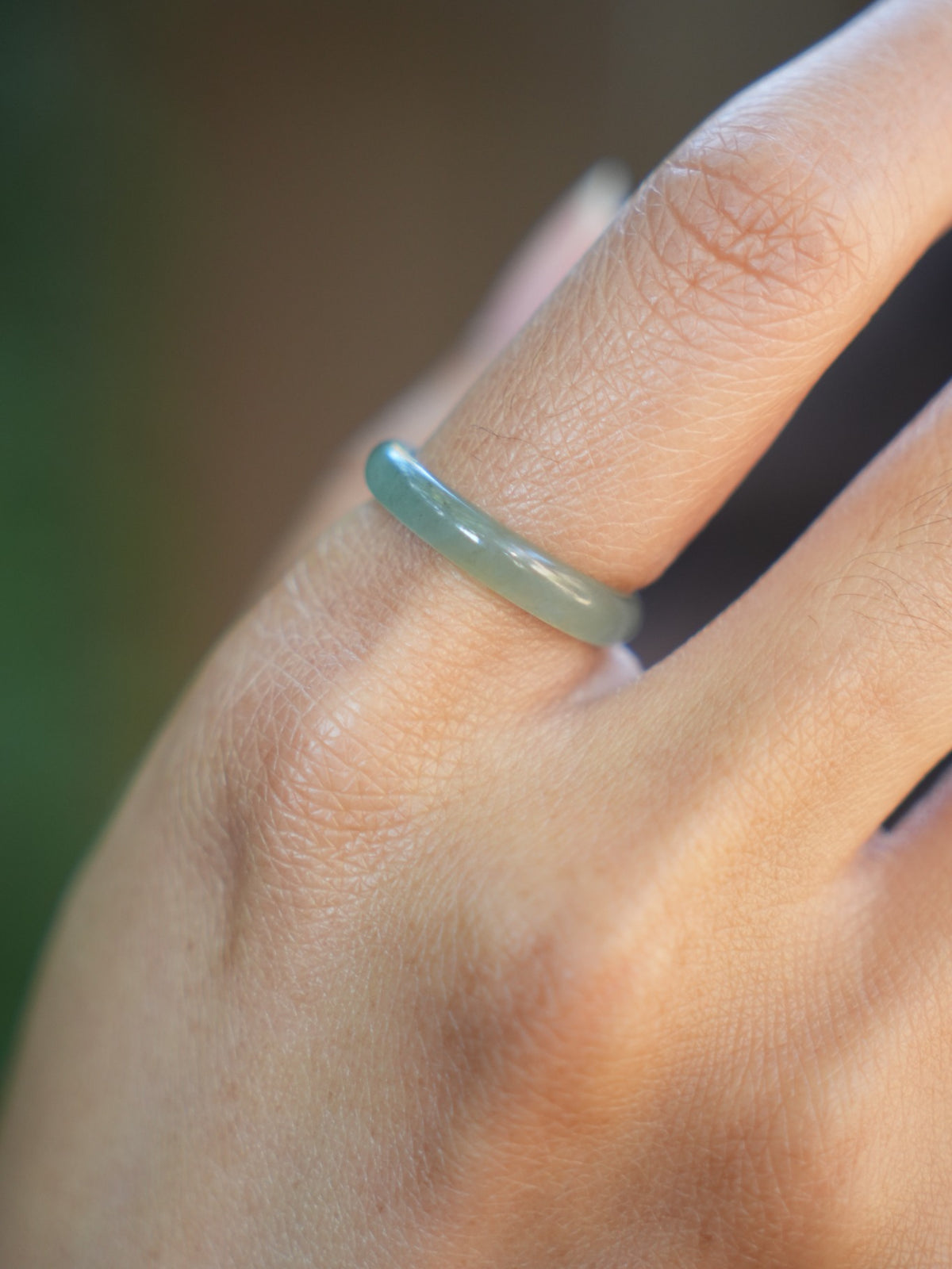 Green jadeite band rings — worn on hand, detail and styling view