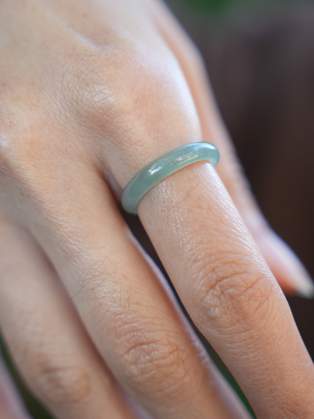 Green jadeite band rings — worn on hand, detail and styling view
