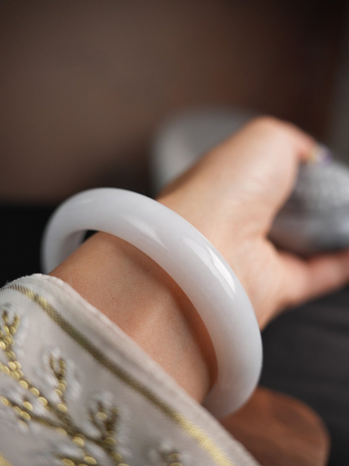 60 mm Type A jadeite bangle with pale green and lavender tones, actual piece P2509005811, worn on wrist
