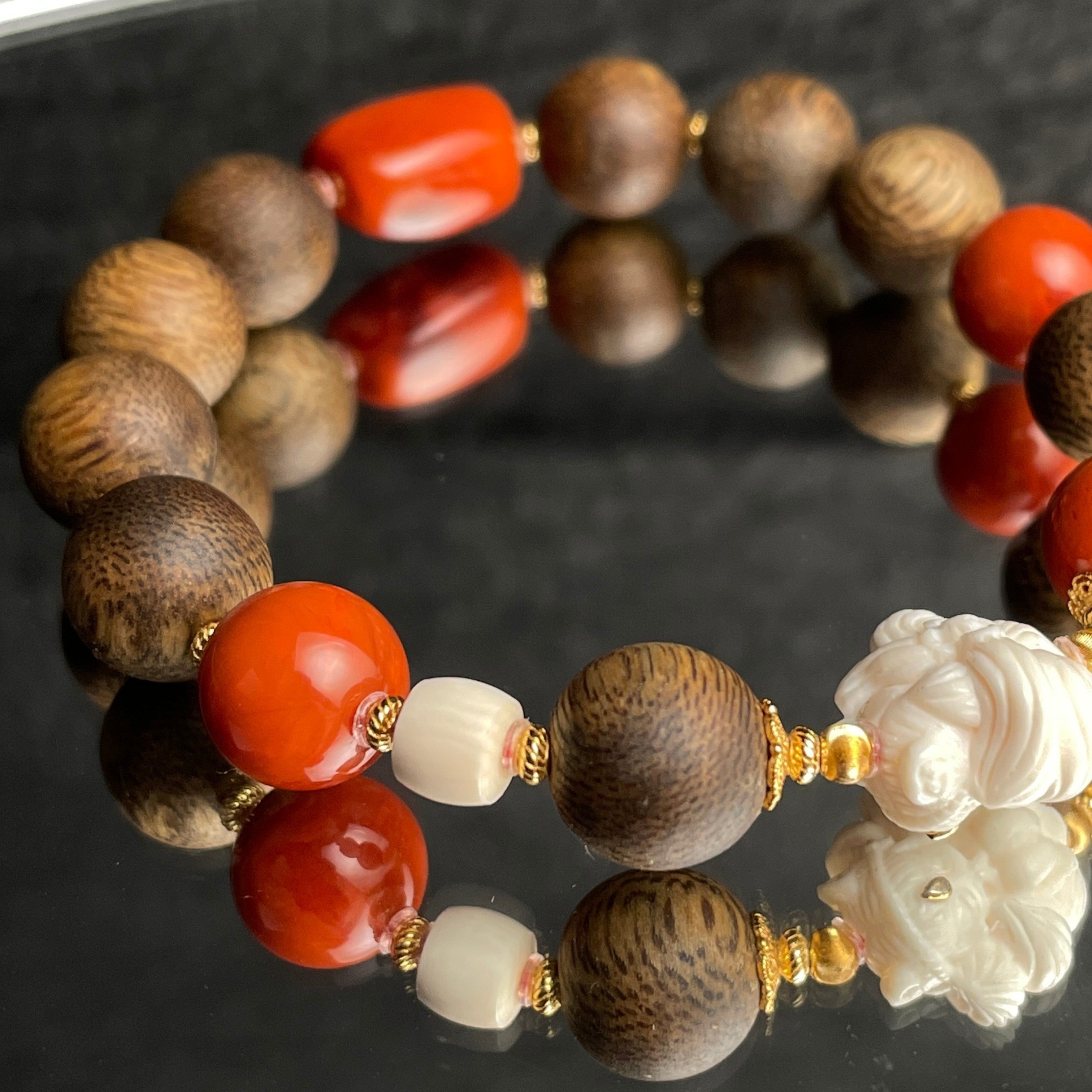 Sylvia Jewelry agarwood bracelet with red Nanhong agate, hand-carved white flower, and gold-plated silver accents.