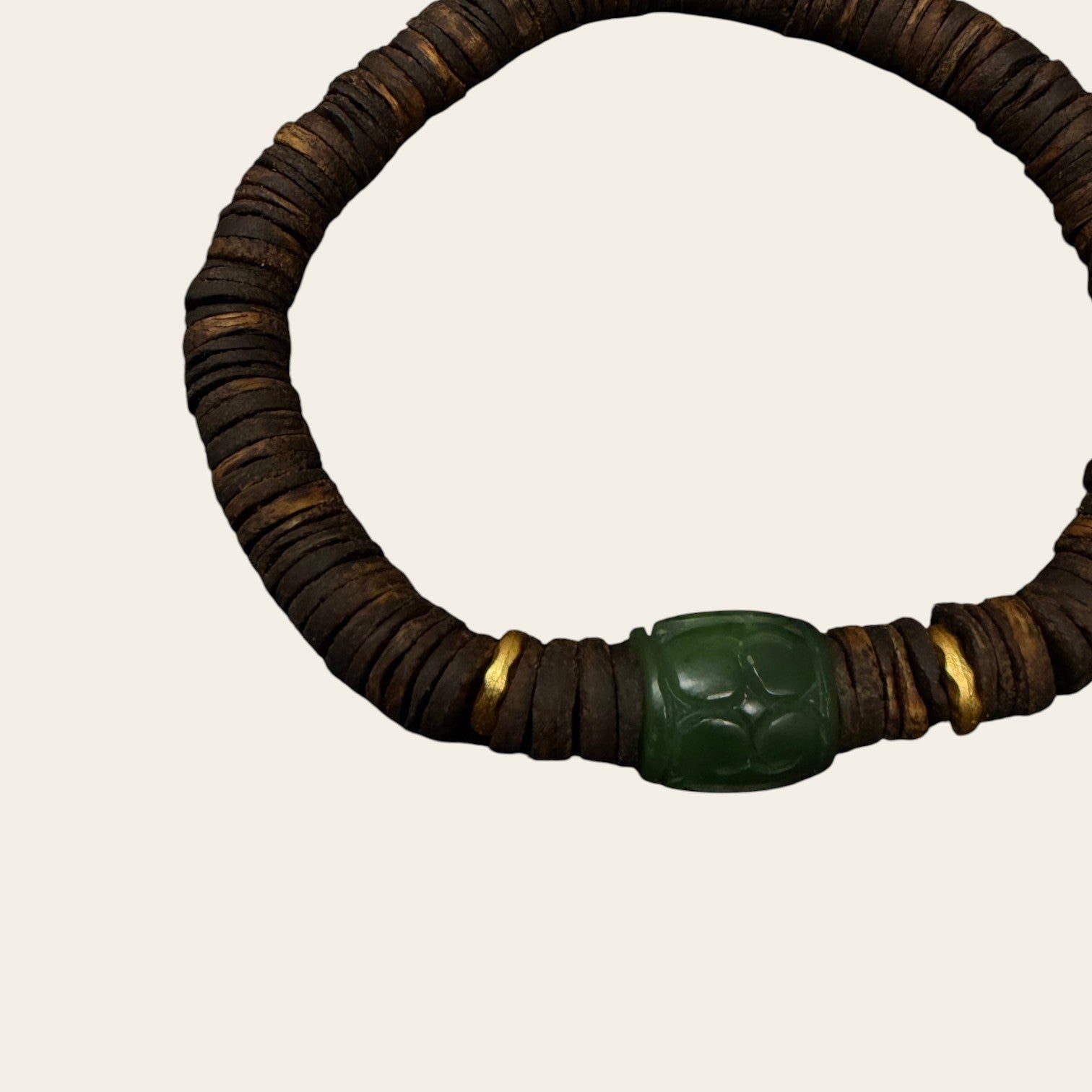 Sylvia Jewelry Rooted Spirit bracelet with dark brown agarwood beads, carved green jade cylinder, and gold accents.