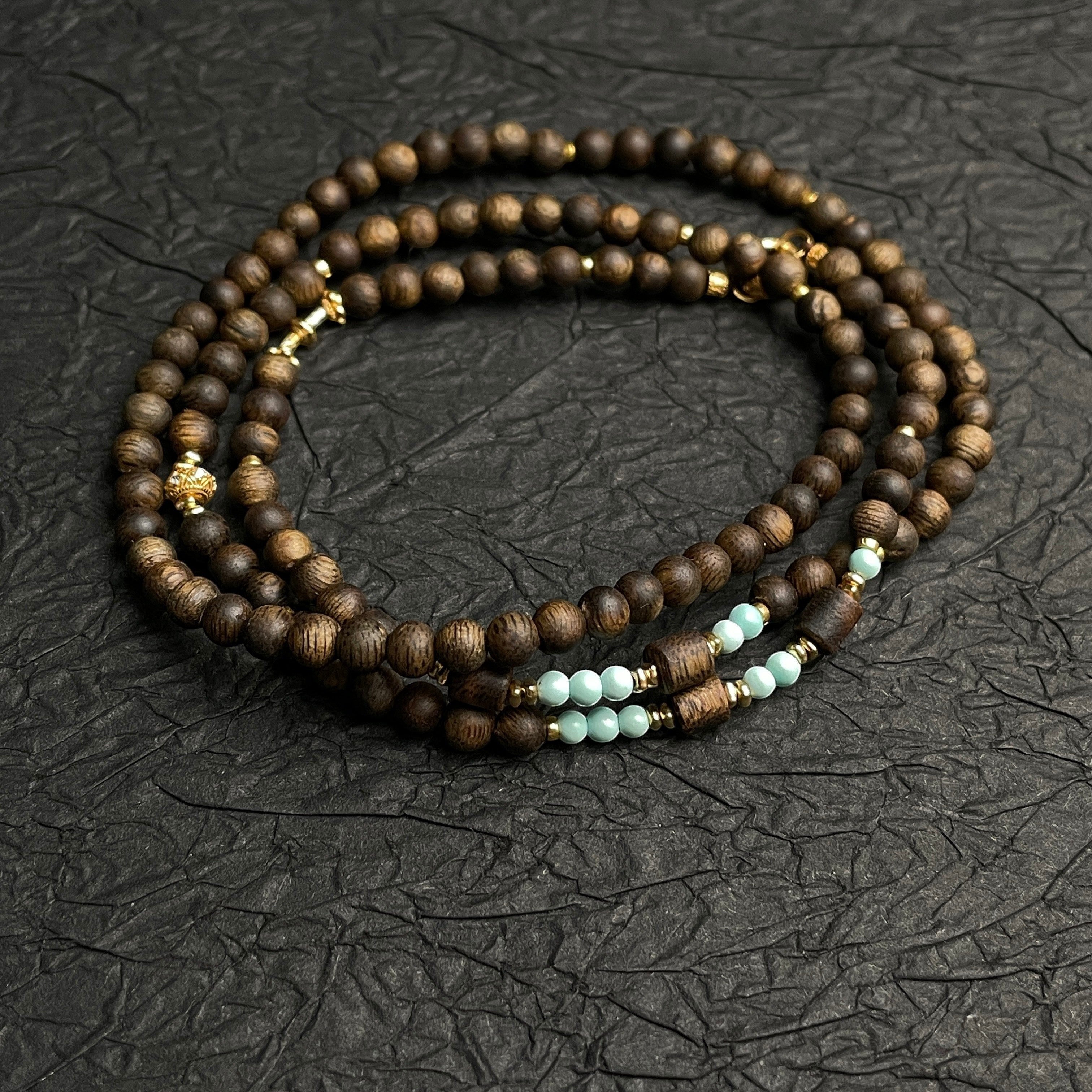 Sylvia Jewelry long necklace featuring natural agarwood beads, mint-green high-porcelain turquoise, and gold accents.