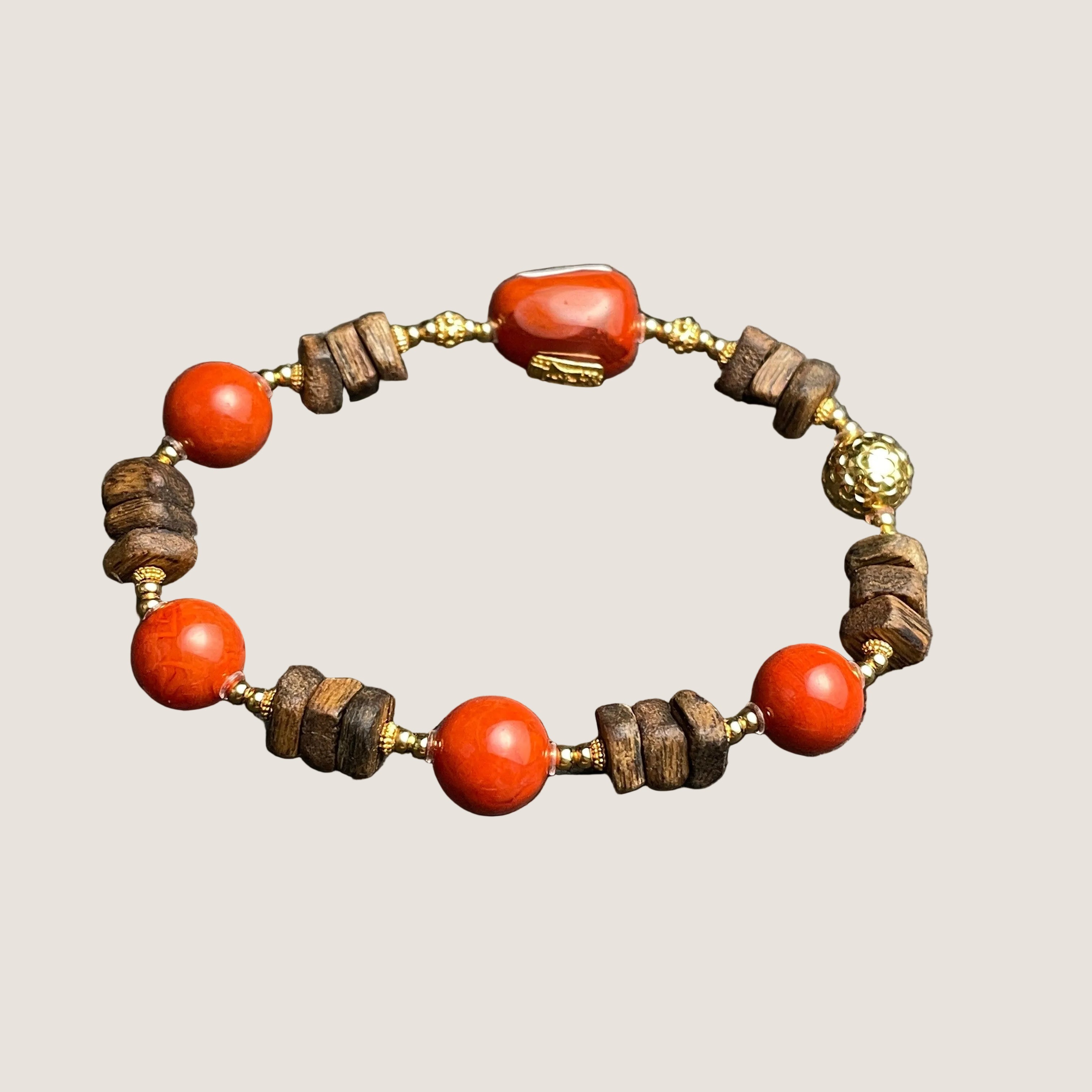 Sylvia Jewelry Nanhong Agate and Agarwood beaded bracelet with gold accents. Features red agate beads and natural wood beads.