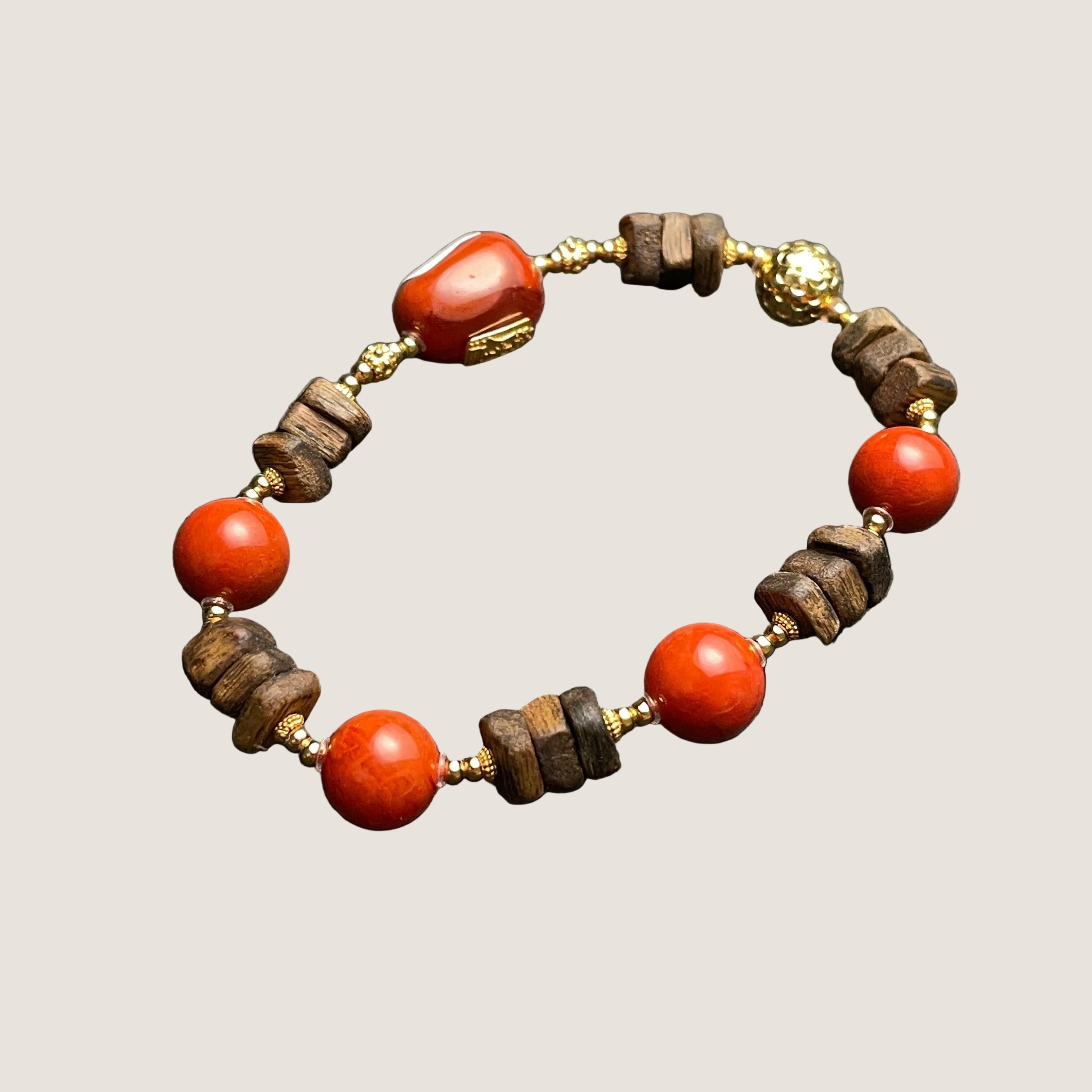 Sylvia Jewelry Nanhong Agate and Agarwood beaded bracelet with gold-plated accents. Features vibrant red agate beads and natural wood beads.