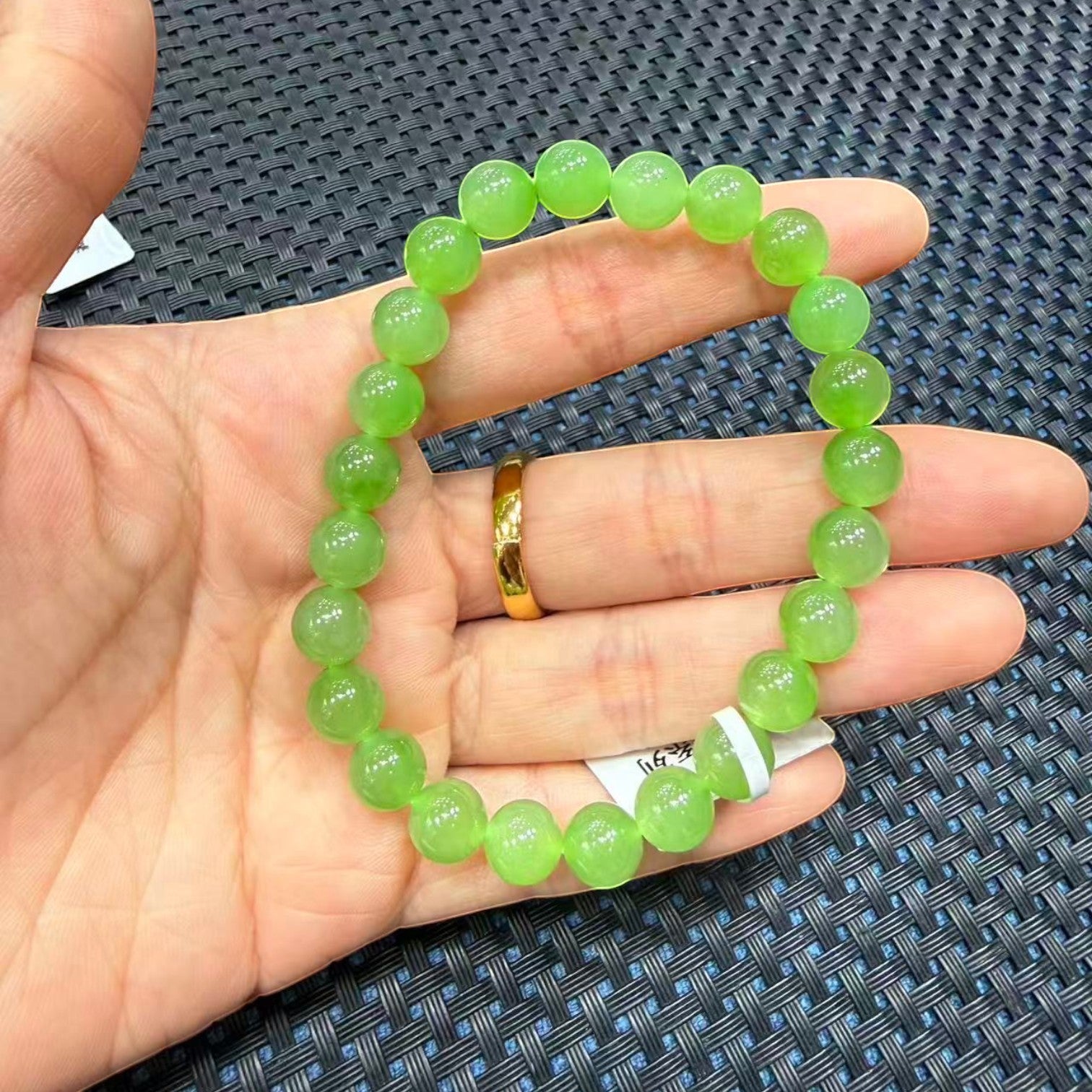 Sylvia Jewelry apple green Ulan-Ude nephrite jade bead bracelet with translucent, vibrant round beads on a hand.