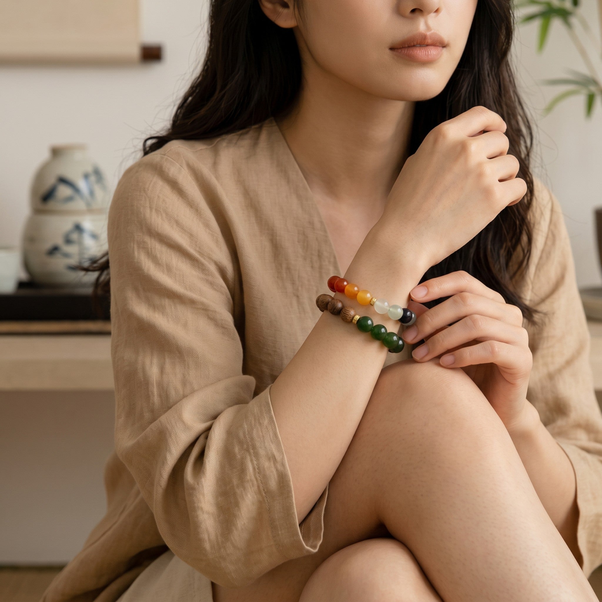 Sylvia Jewelry multi-colored gemstone and wooden bead bracelet worn by a woman in a serene indoor setting