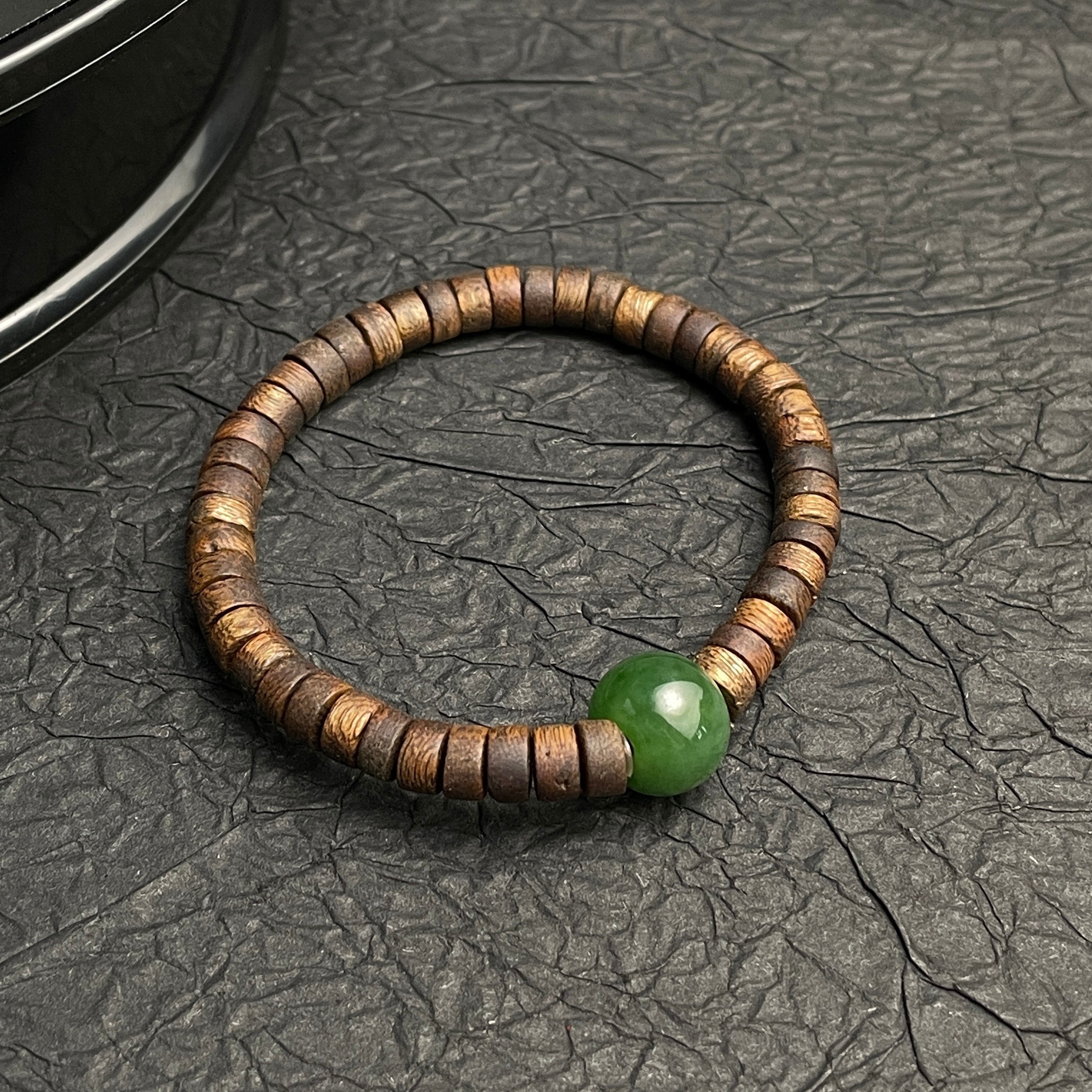 Sylvia Jewelry bracelet featuring a spinach green Hetian nephrite jade bead and natural aromatic agarwood abacus beads.
