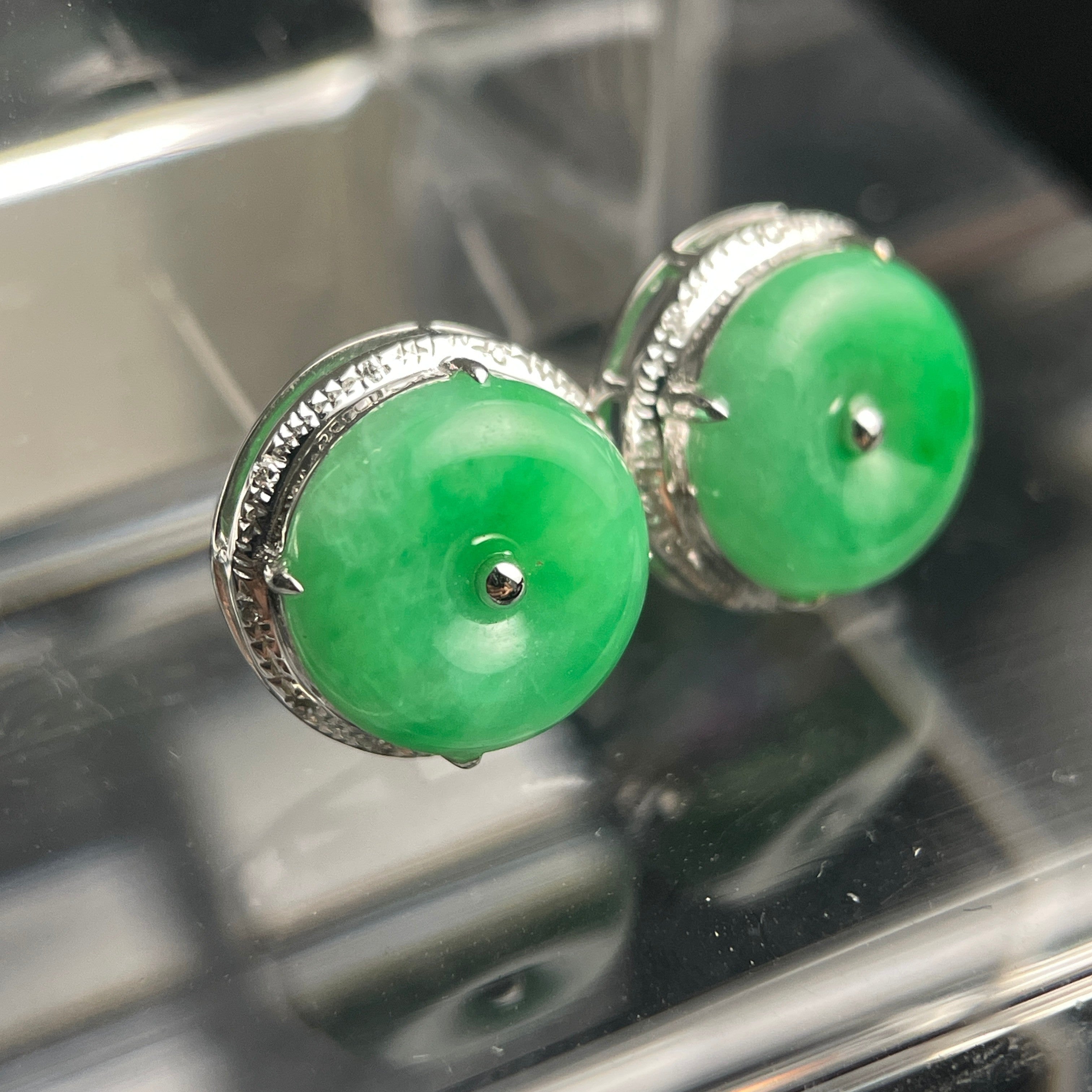 Sylvia Jewelry green jadeite disc stud earrings with silver-tone textured metal settings on a reflective surface.
