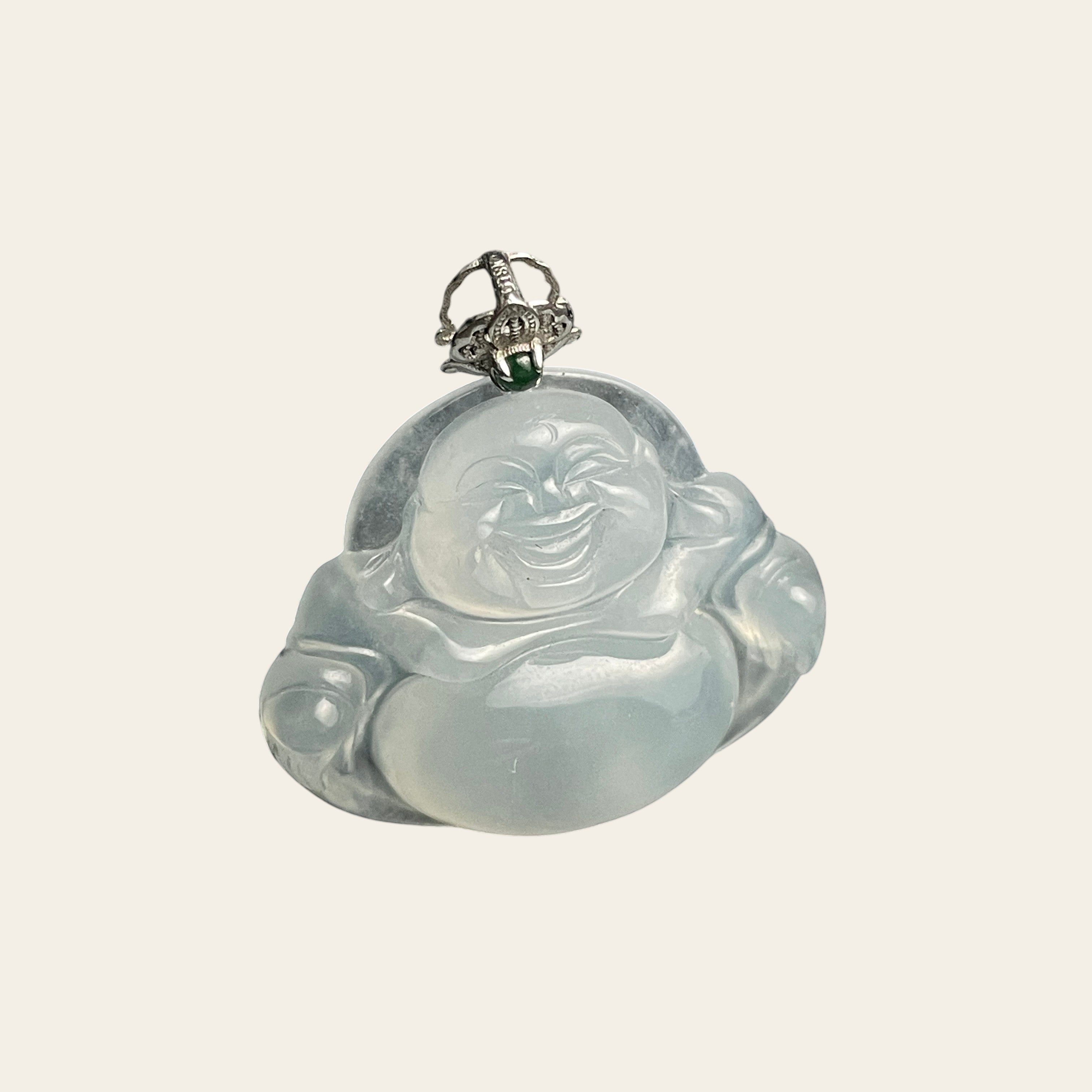 Sylvia Jewelry translucent icy jadeite Buddha pendant with a decorative silver bail on a black textured background.
