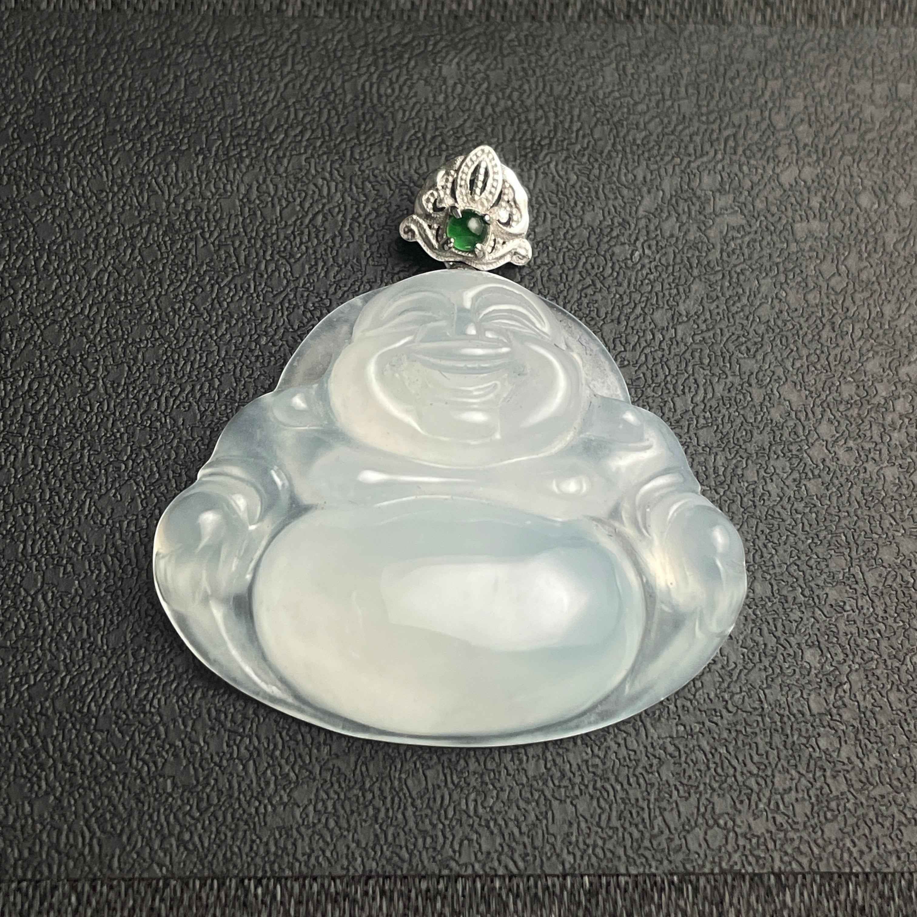 Sylvia Jewelry translucent white jadeite laughing Buddha pendant with a silver bail and small green gemstone accent.