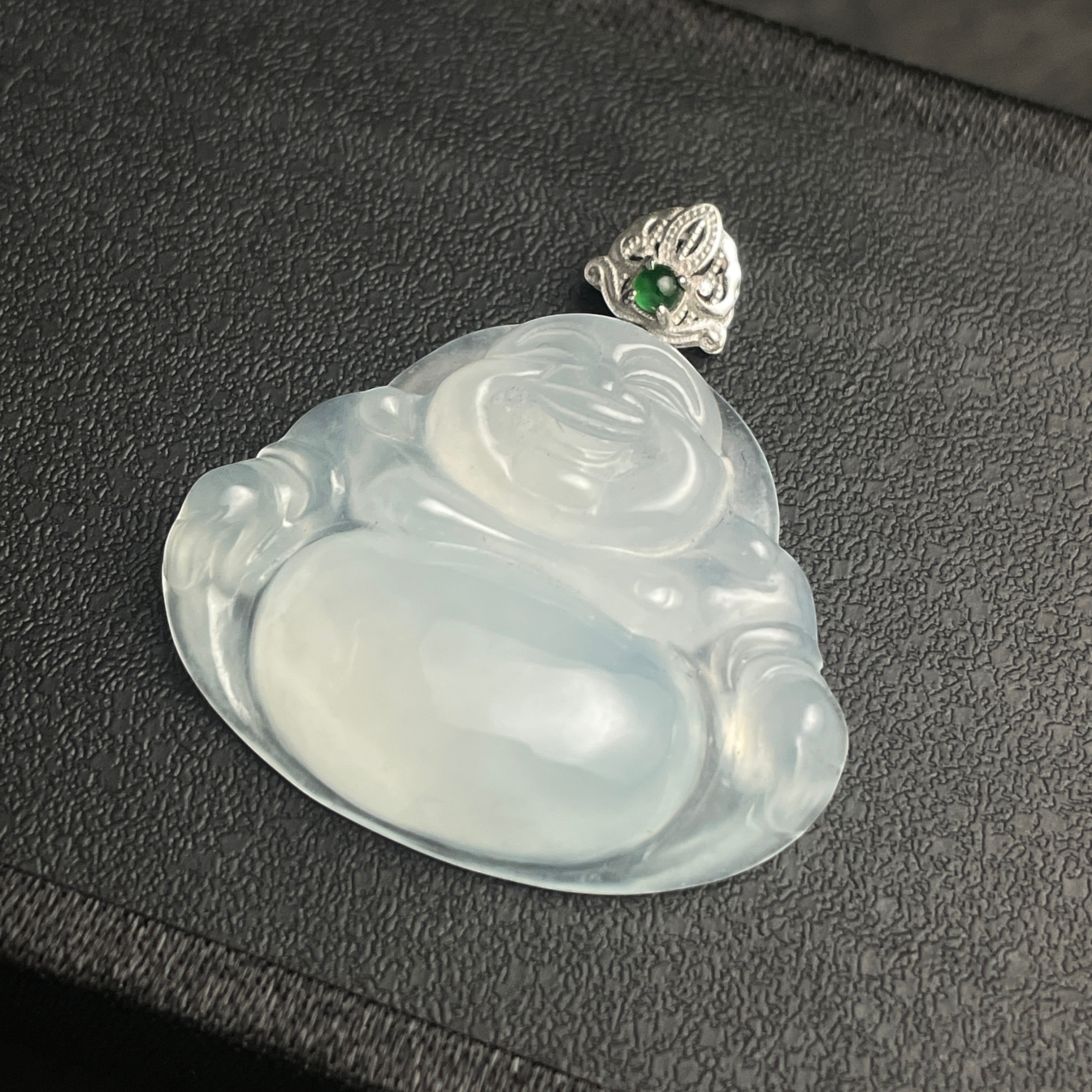 Sylvia Jewelry translucent white jadeite Buddha pendant with a silver bail and small green gemstone accent.