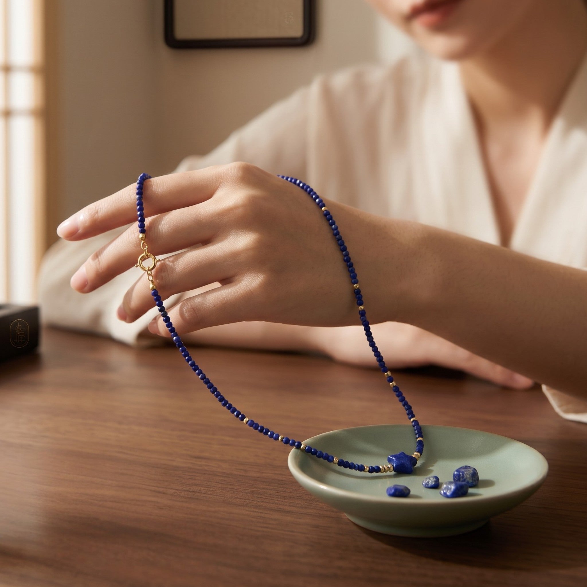 Sylvia Jewelry lapis lazuli beaded choker with gold-plated star pendant worn by a woman in a serene studio setting.