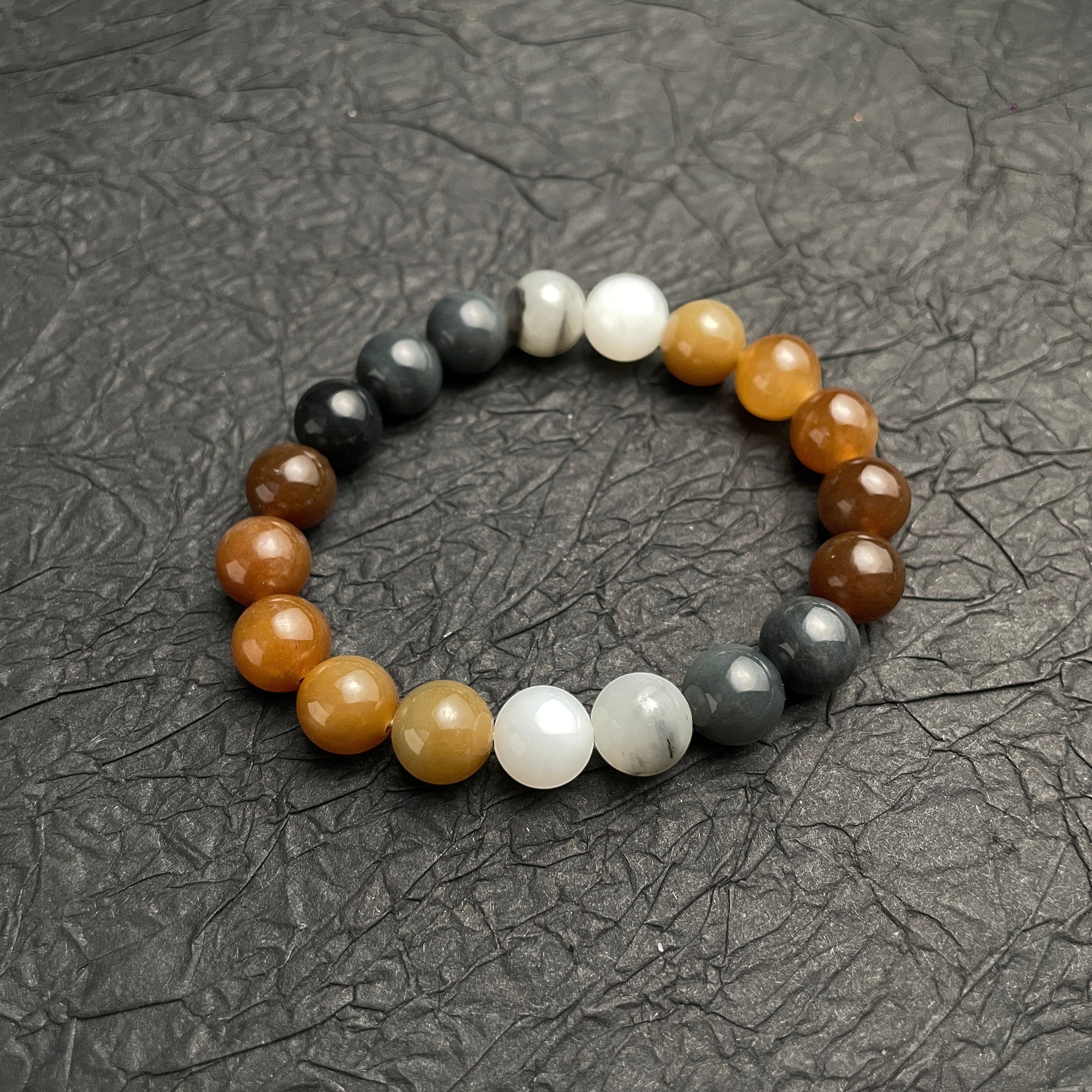 Sylvia Jewelry multi-colored Hetian nephrite jade bead bracelet featuring a gradient of amber, white, and ink-black stones.