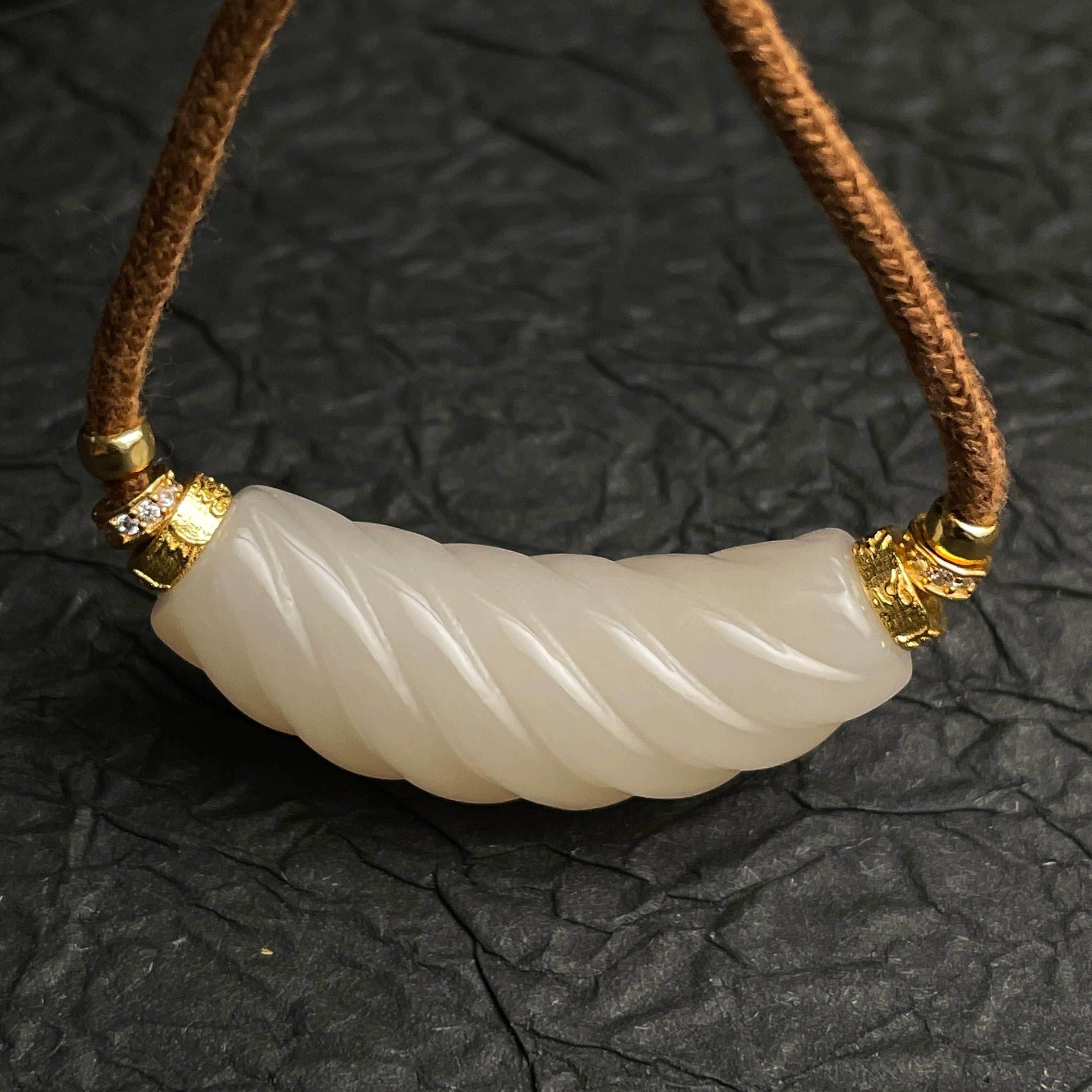 Sylvia Jewelry 扭纹粉色和田玉吊坠,金色镶嵌,搭配棕色绳链,适合日常优雅佩戴。