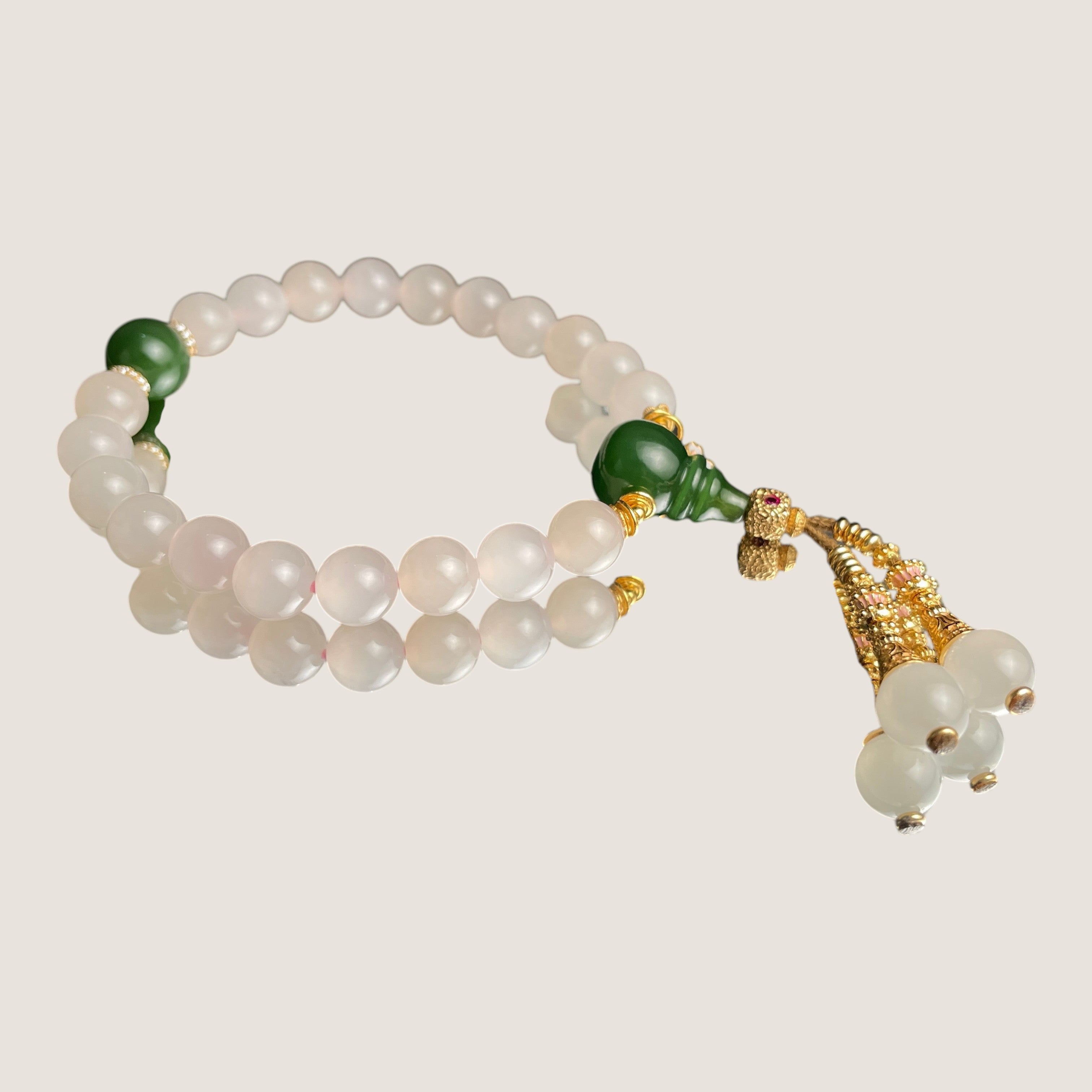 Sylvia Jewelry 浅粉色玉石佛珠手链,点缀绿色玛瑙和金色流苏,适合日常佩戴。