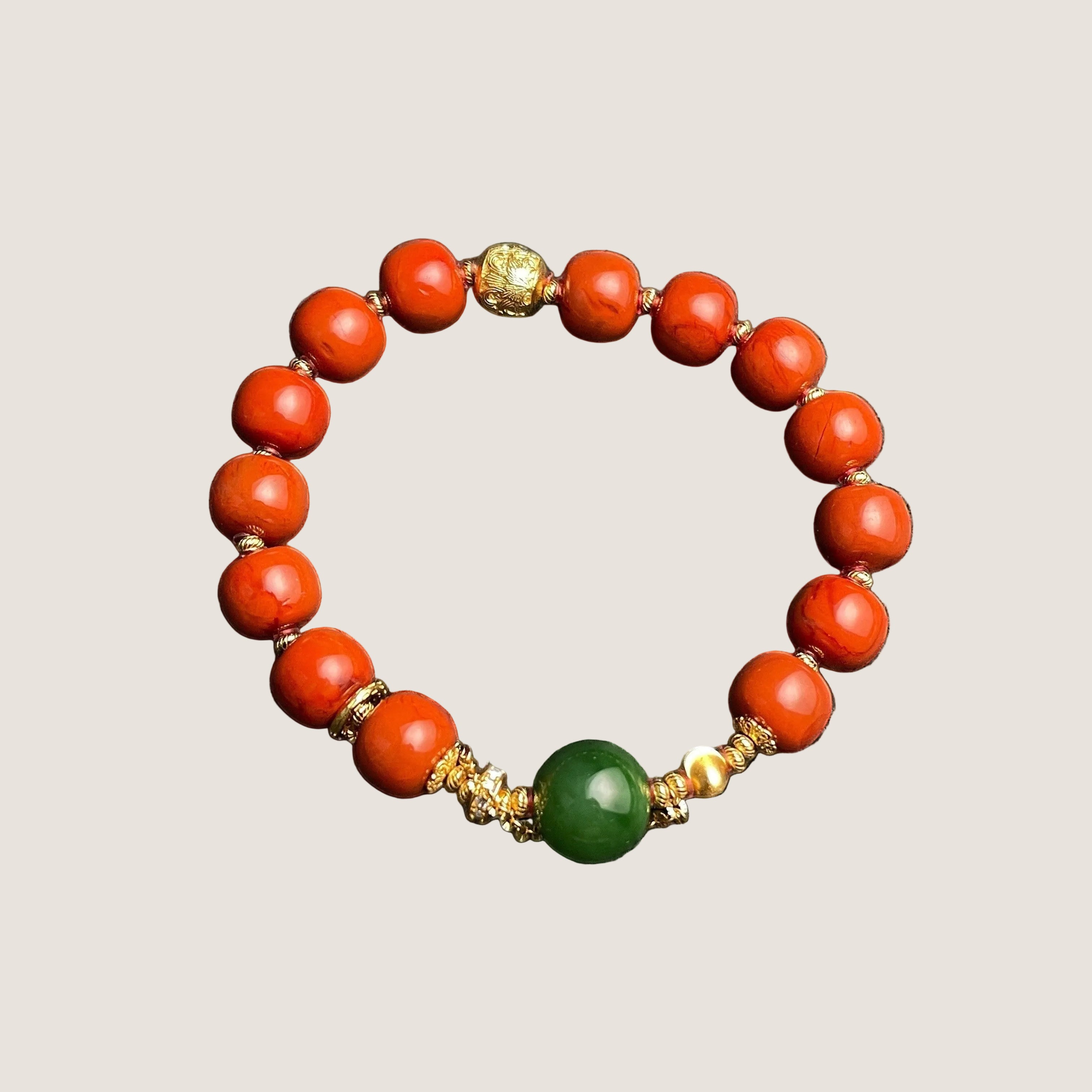 Sylvia Jewelry bracelet with vibrant red Nanhong Agate beads, a central green Hetian Jade bead, and gold-plated silver spacers.