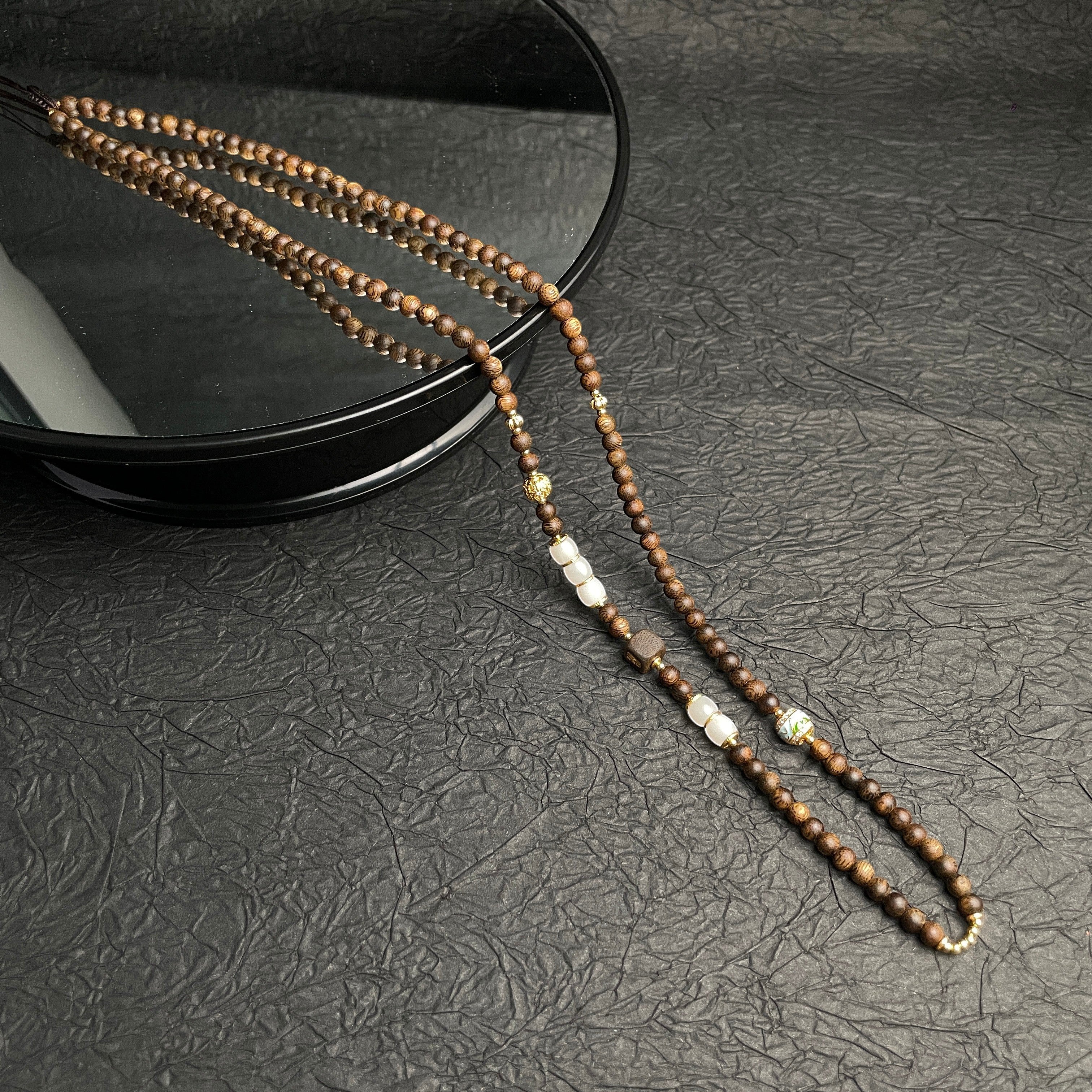 Sylvia Jewelry long beaded necklace featuring brown sandalwood beads with white stone and gold accent spacers