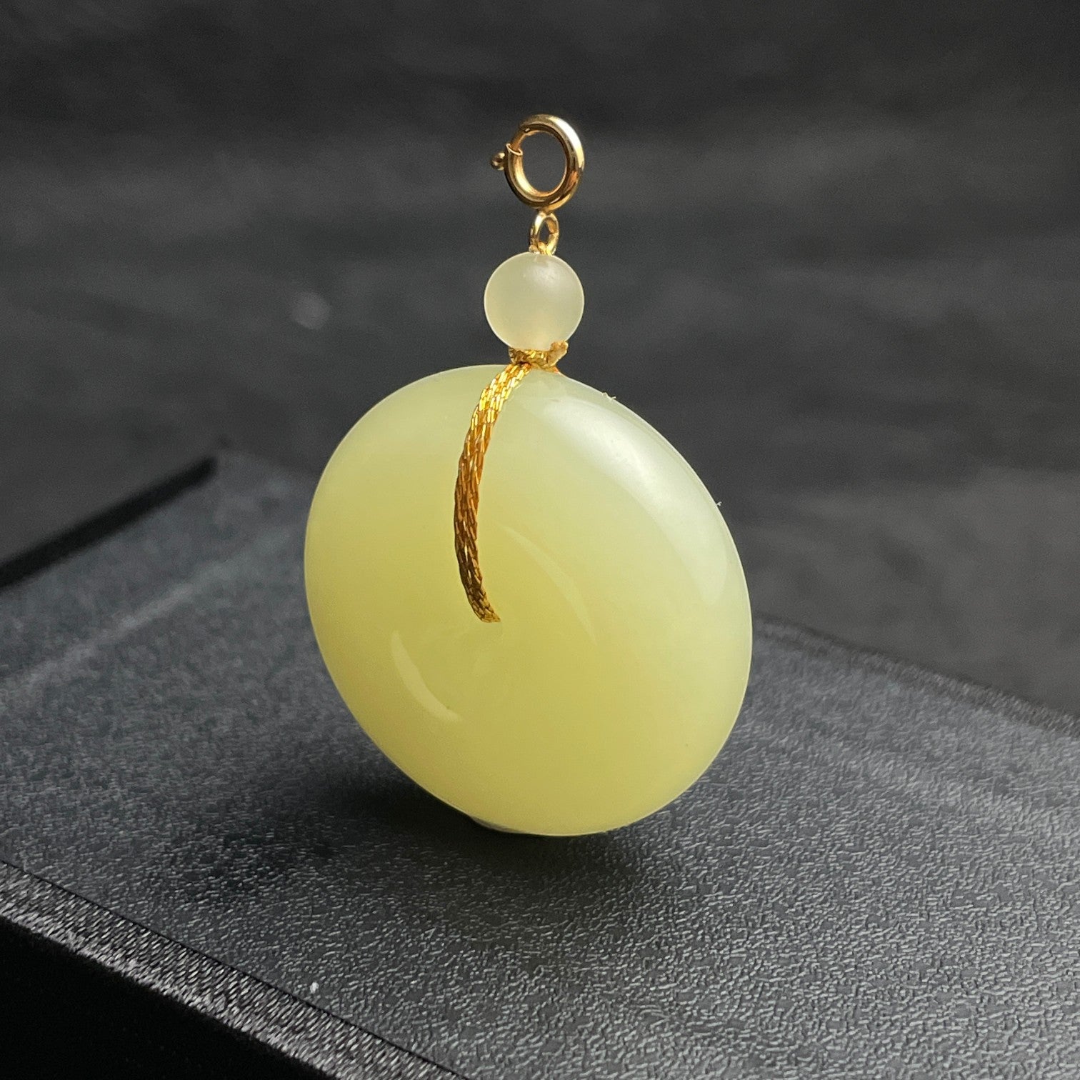 Sylvia Jewelry pale yellow Hetian jade Ping An Kou pendant with gold-plated silver hardware and cord-wrap accent.