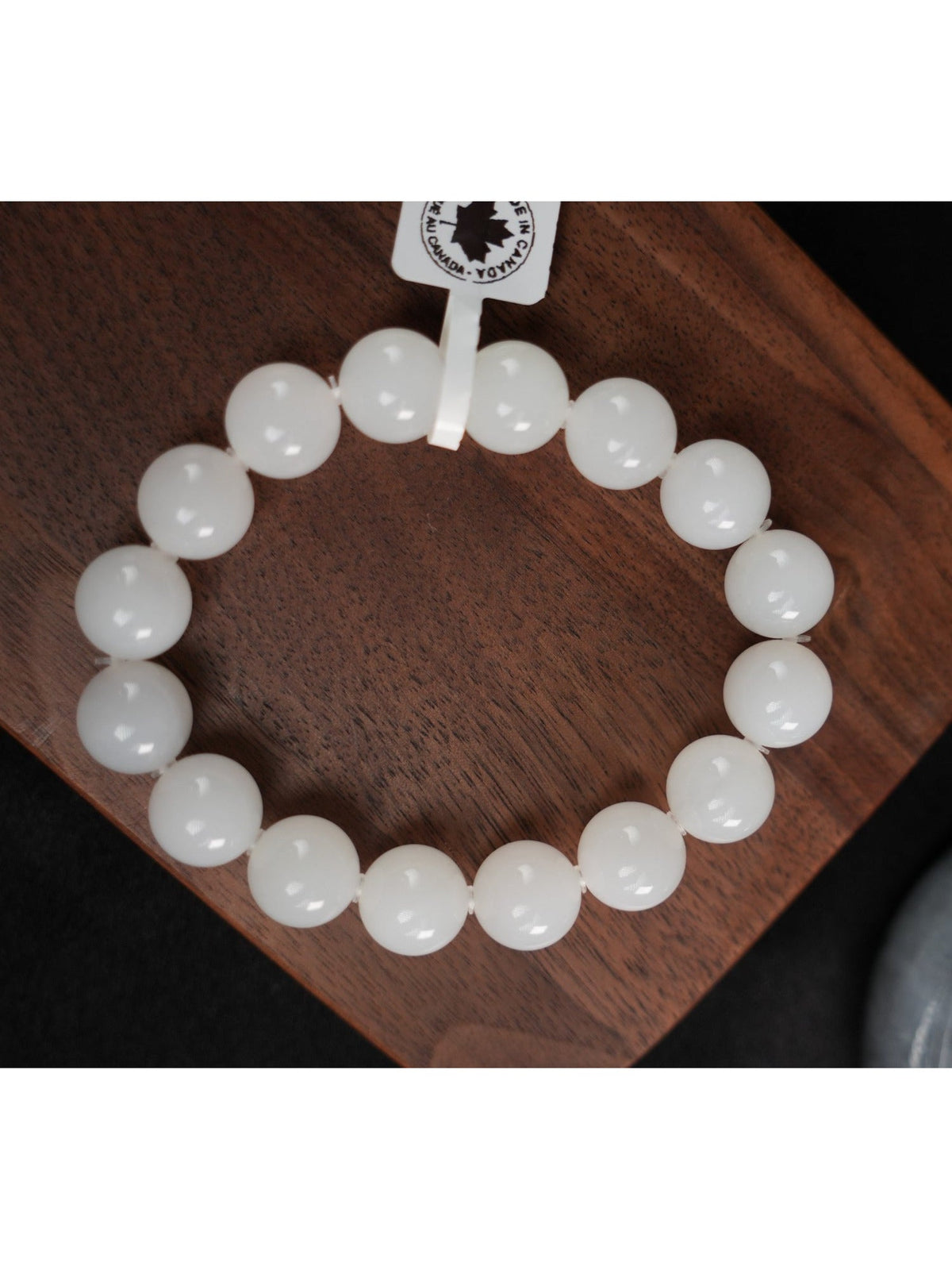White Hetian nephrite jade round bead bracelet on wooden display, B12609024891