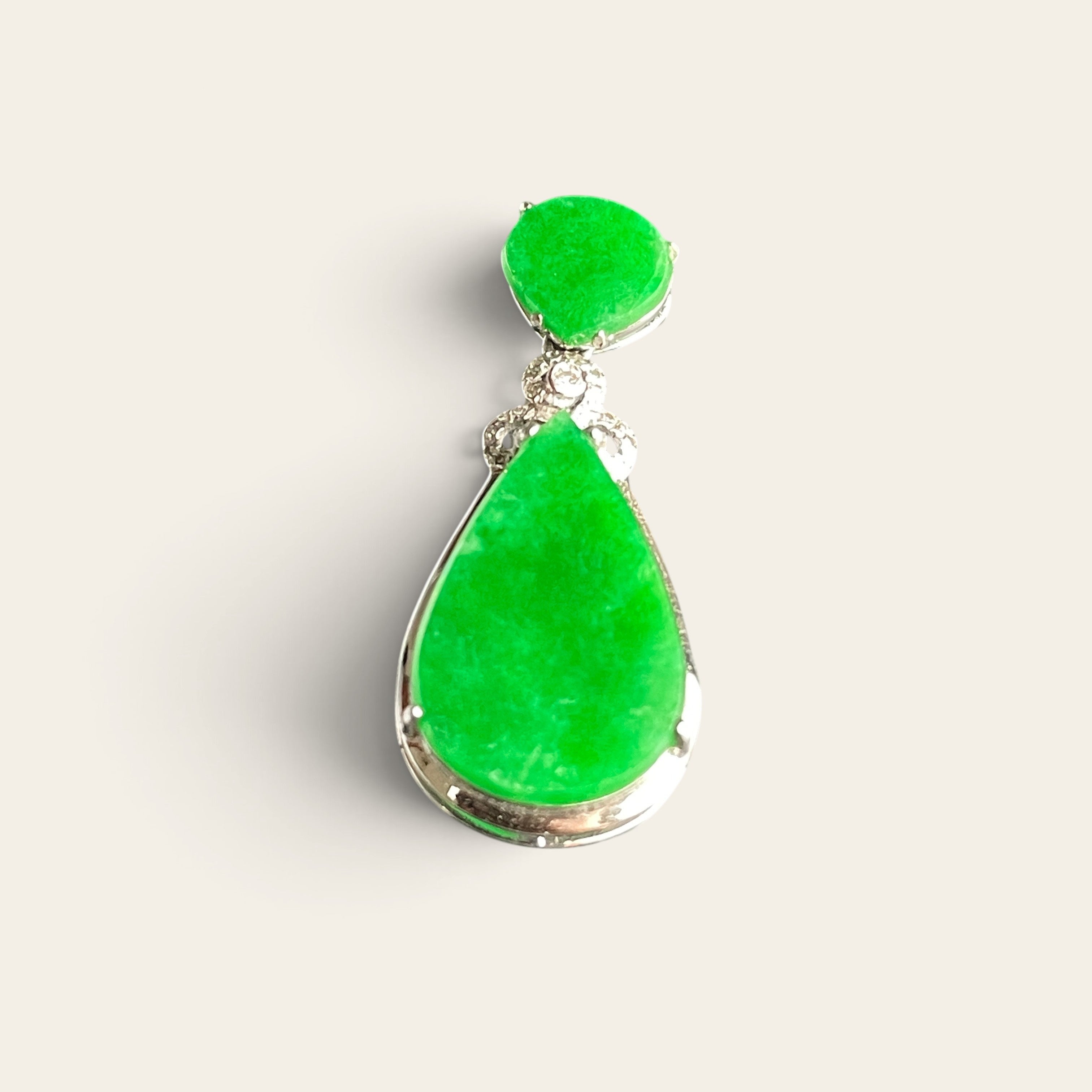Vivid green jadeite teardrop pendant set in 18K gold with a floral diamond-accented bail