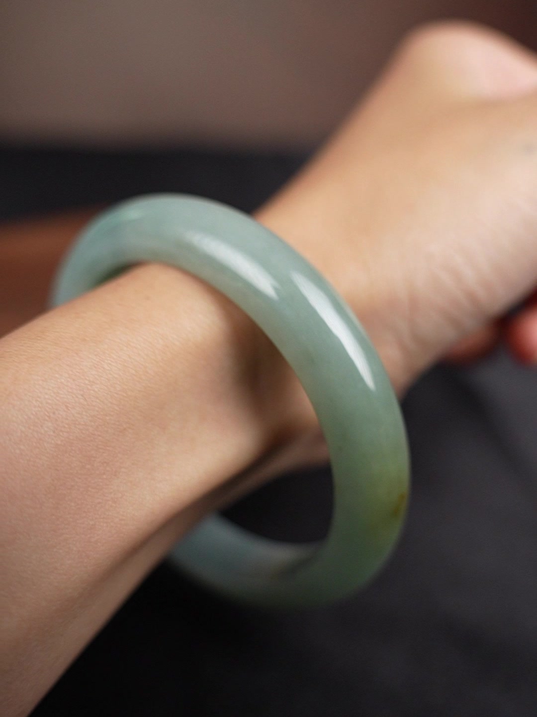 Pale green Type A jadeite bangle worn on wrist, angle 2