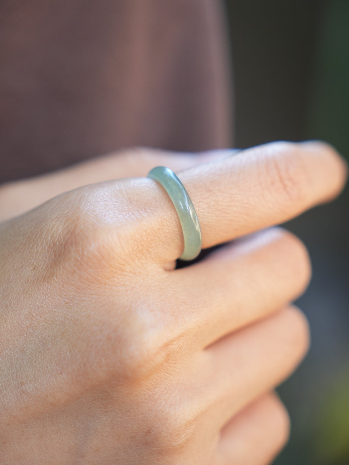 Green jadeite band rings — worn on hand, detail and styling view