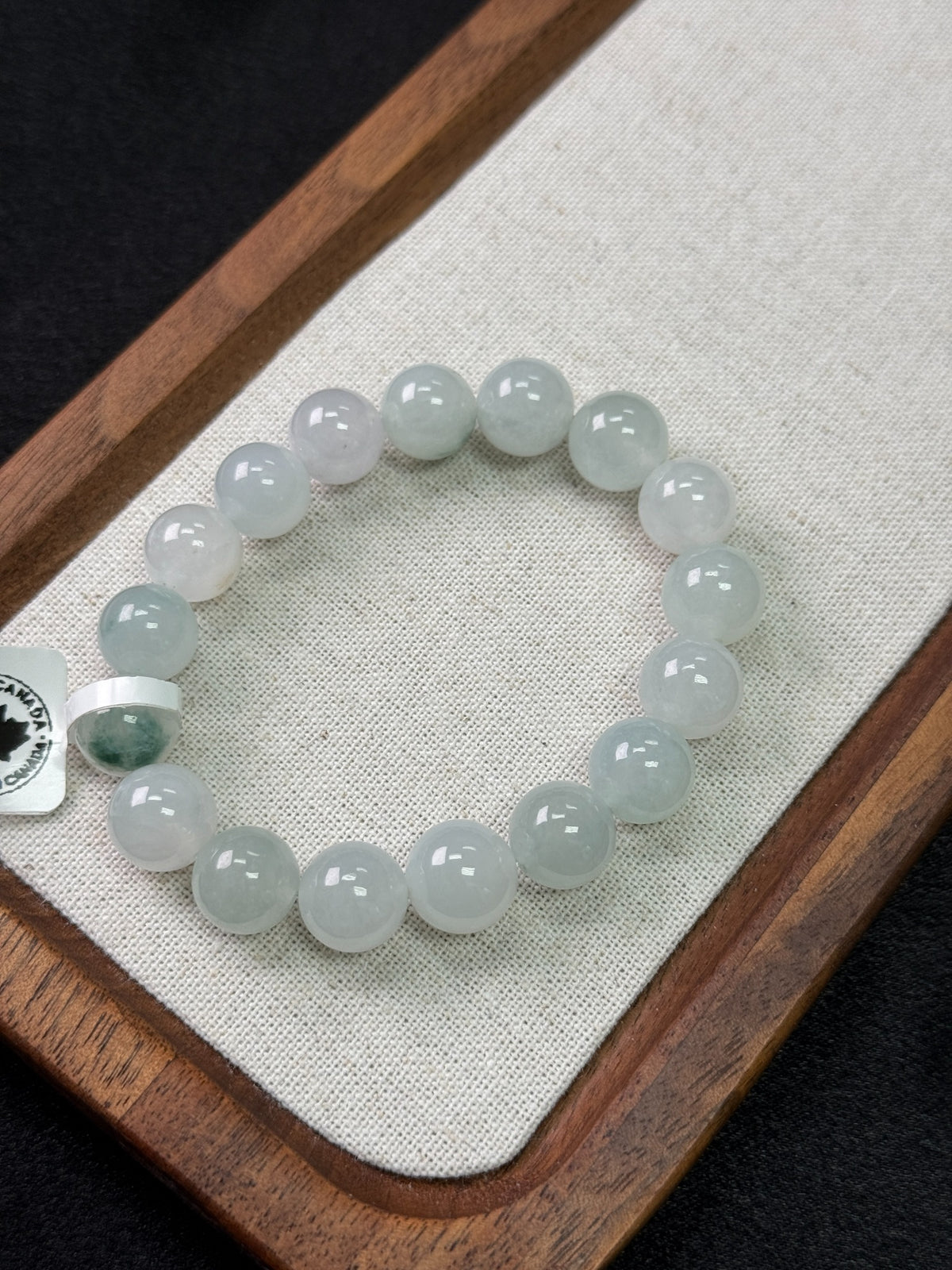 10.5 mm jadeite bead bracelet on a linen tray