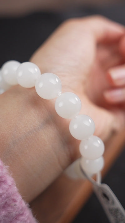 12 mm white Hetian nephrite jade bracelet worn on wrist, B12609024891; soft piano accompaniment.