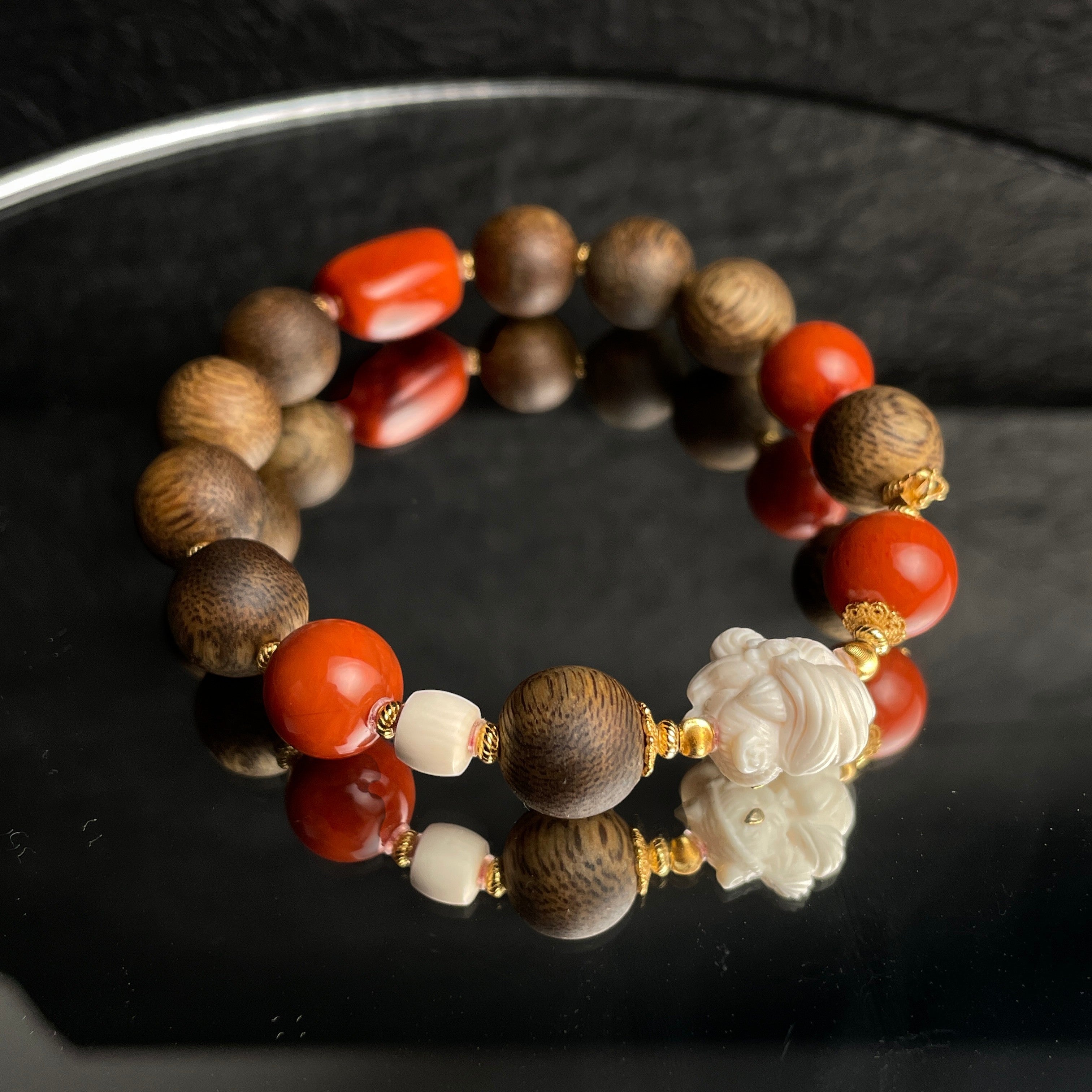Sylvia Jewelry agarwood bracelet featuring red Nanhong agate beads, gold-plated silver accents, and a carved blossom.