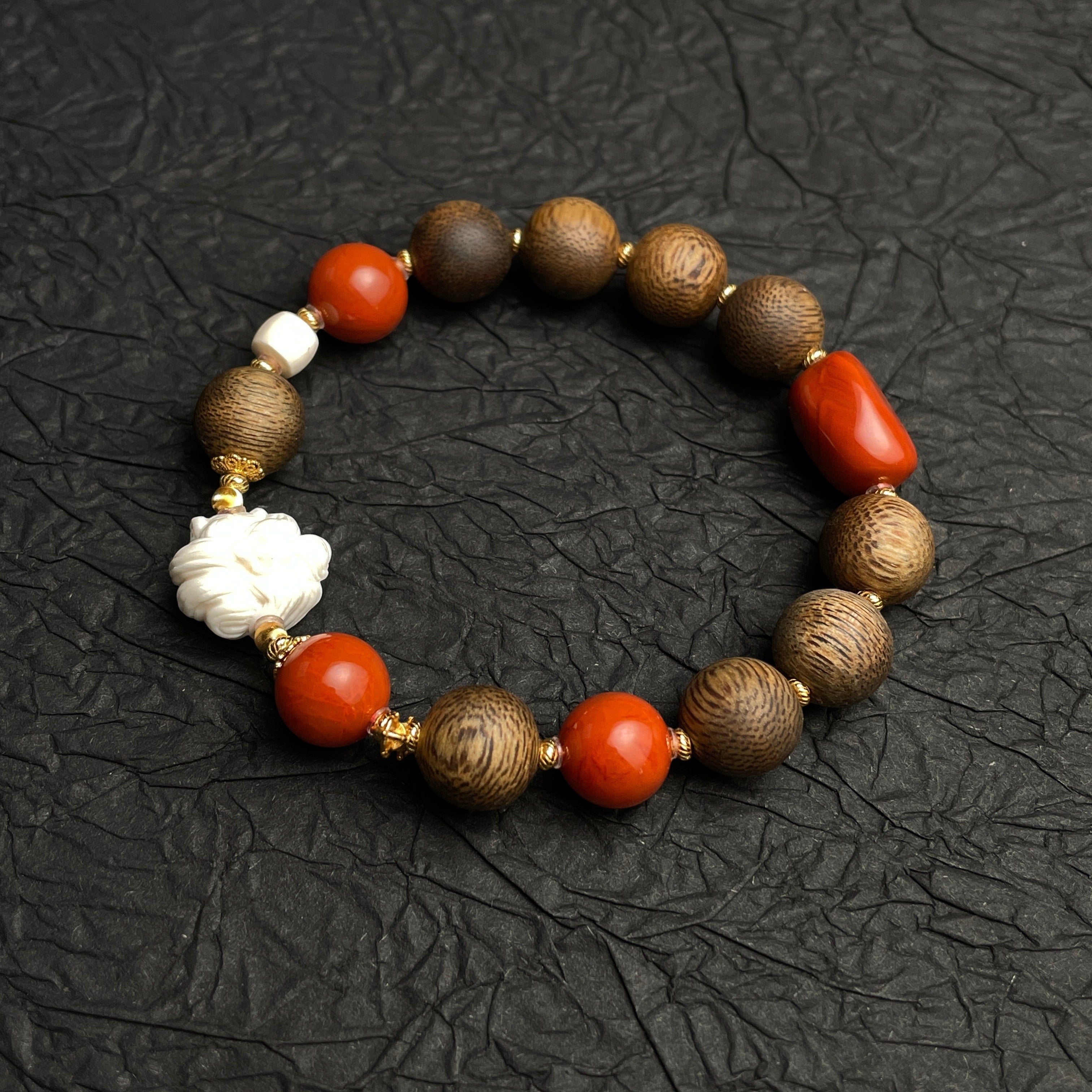 Sylvia Jewelry Forbidden Bloom bracelet featuring agarwood beads, red Nanhong agate, and a hand-carved white flower charm.