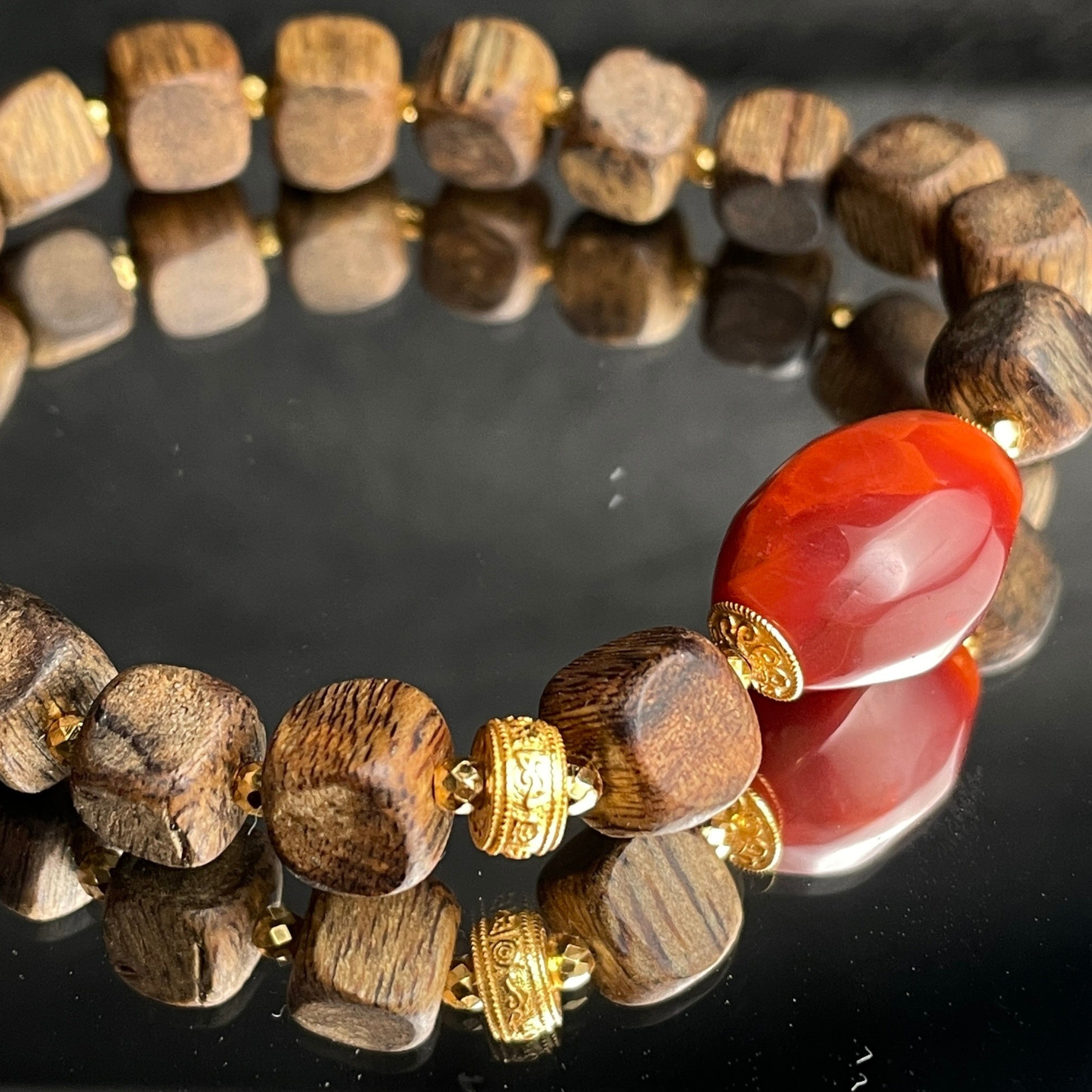 Sylvia Jewelry agarwood cubic bead bracelet with a central red Nanhong agate barrel and gold-plated artisan spacers.