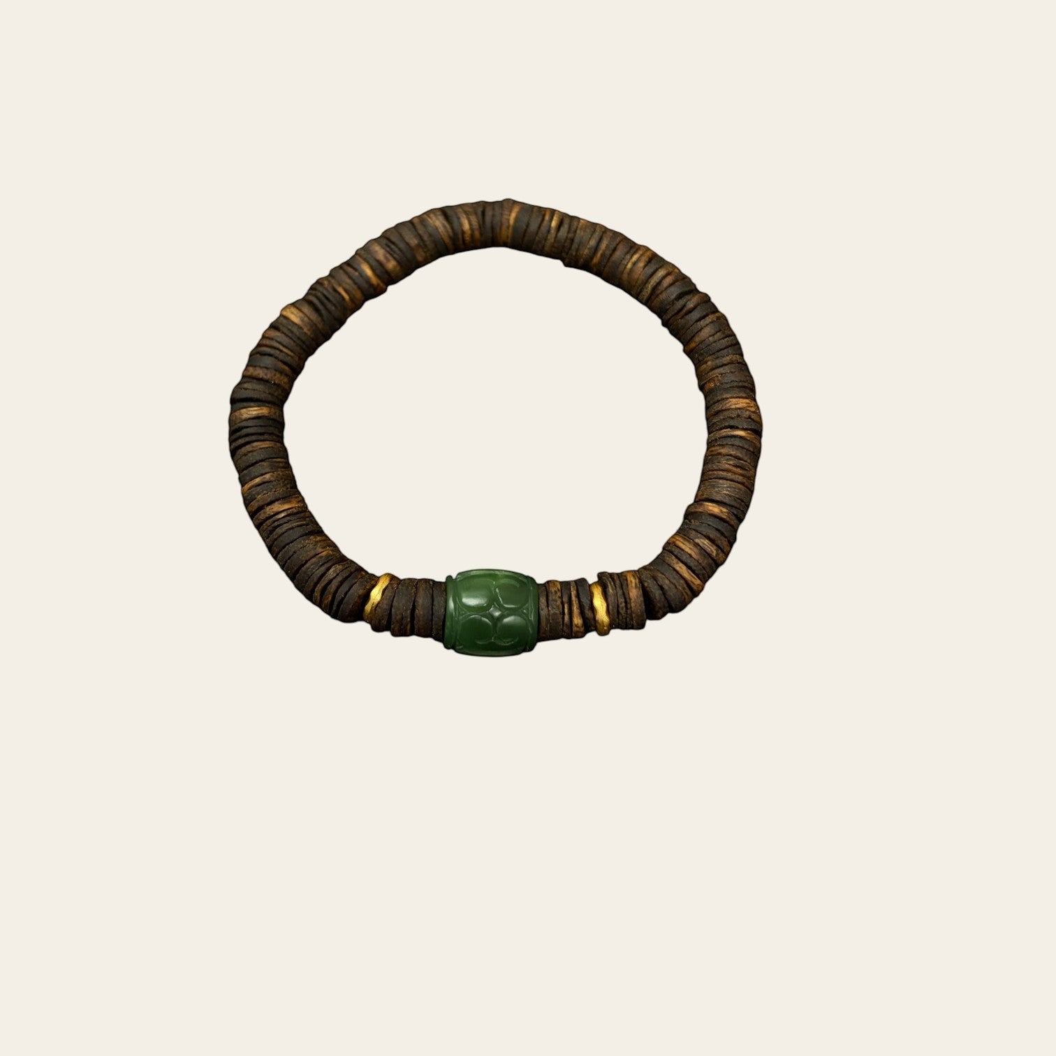 Sylvia Jewelry Rooted Spirit bracelet featuring dark agarwood beads, a carved green jade cylinder, and gold accents.