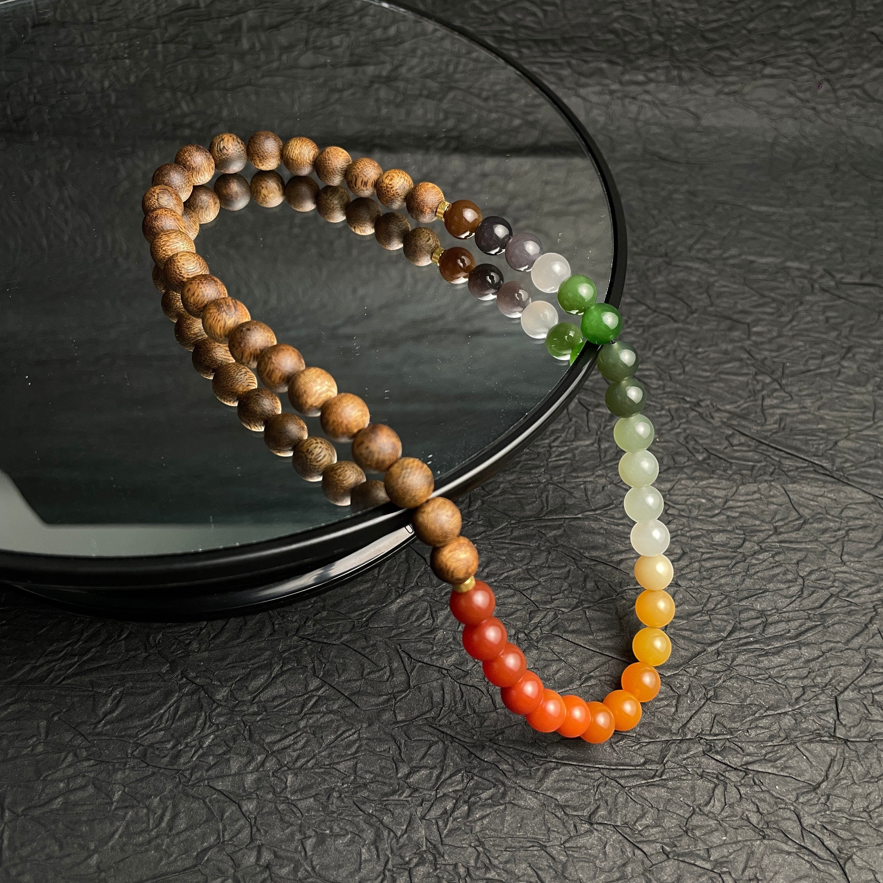 Sylvia Jewelry multi-wrap bracelet featuring natural agarwood beads and a gradient of colorful Hetian nephrite jade.