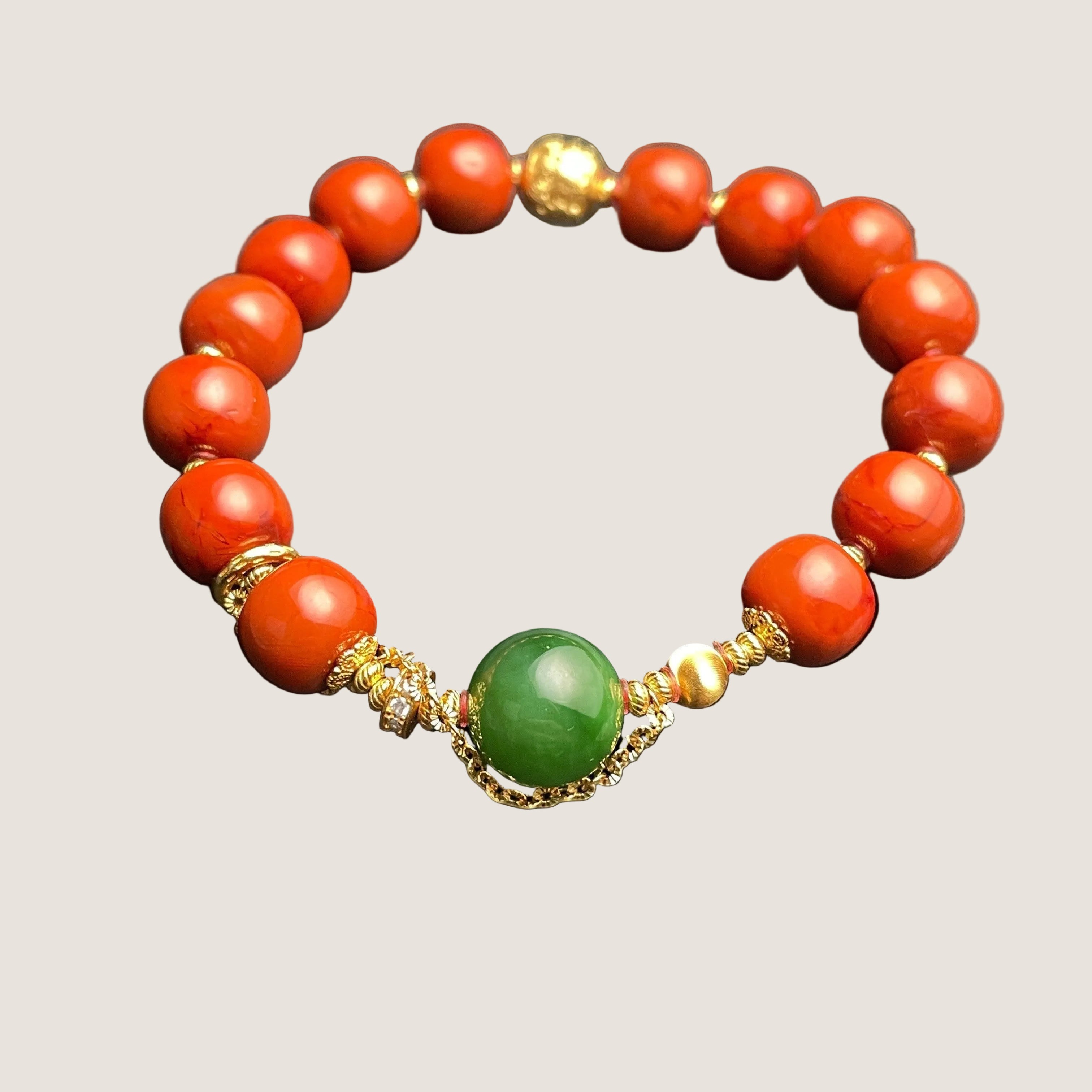 Sylvia Jewelry bracelet with vibrant red Nanhong Agate beads, a central green Hetian Jade bead, and gold-plated silver spacers.