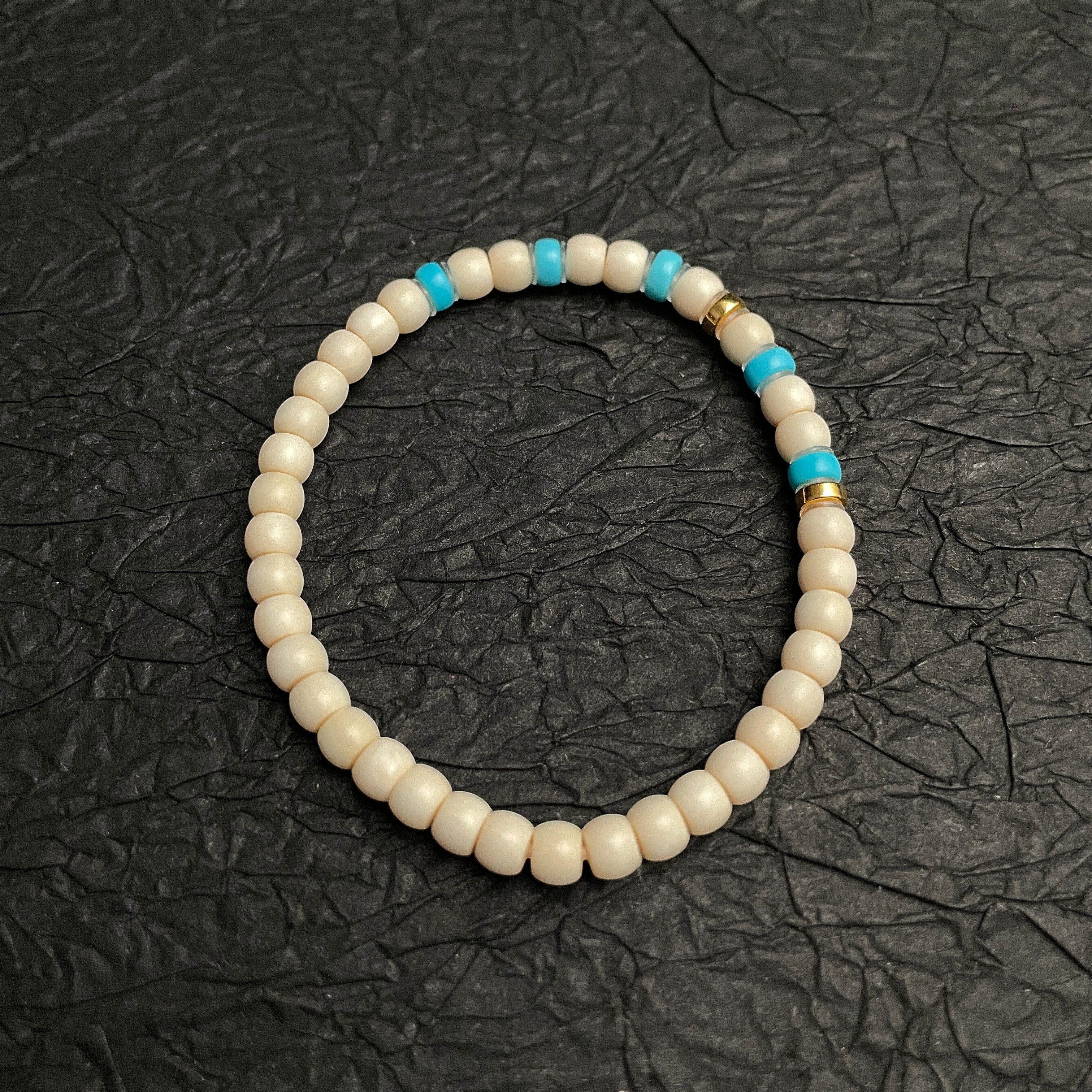 Sylvia Jewelry cream-colored beaded bracelet with turquoise accents and gold spacers, ideal for daily wear.