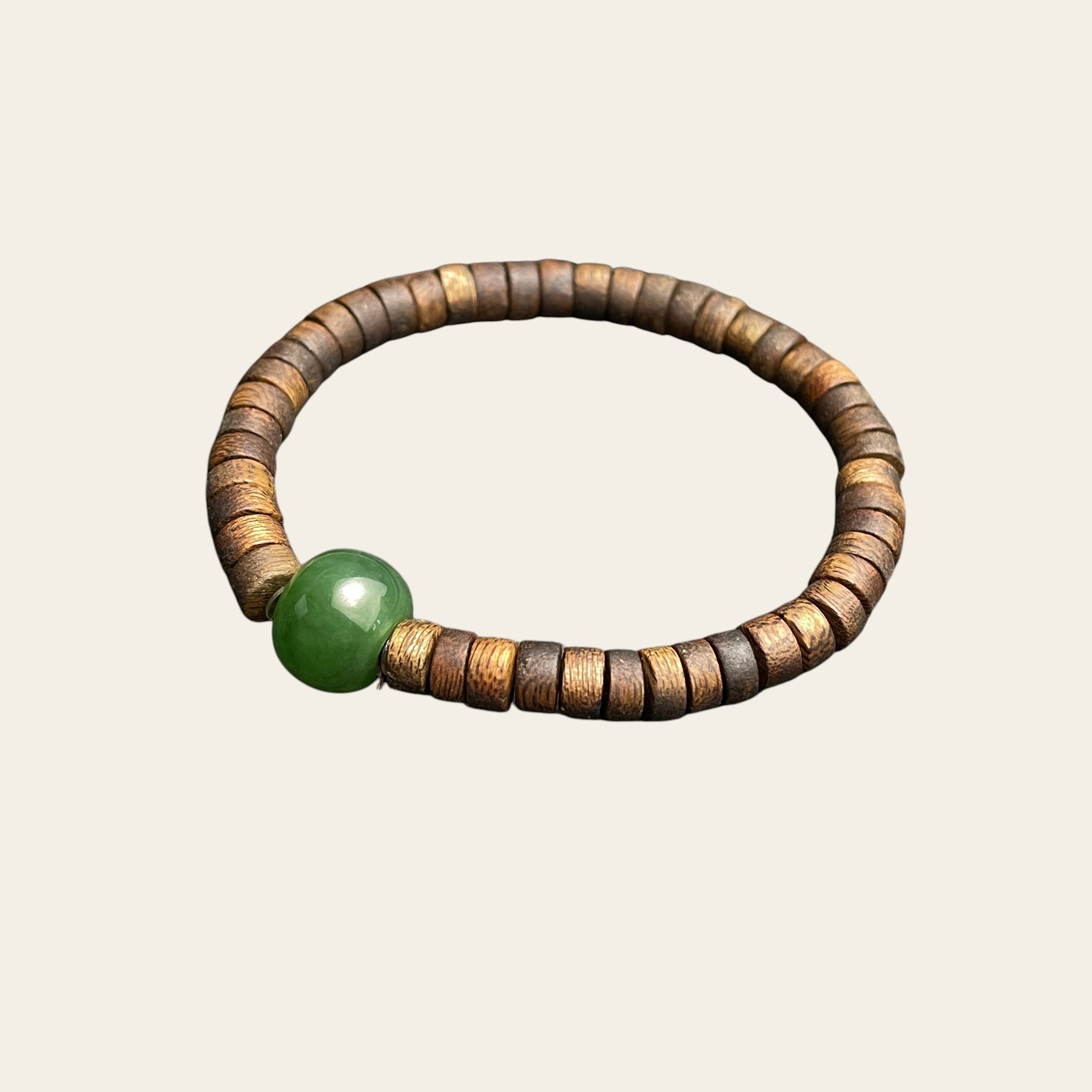 Sylvia Jewelry bracelet featuring a spinach green Hetian nephrite jade bead and natural aromatic agarwood abacus spacers.