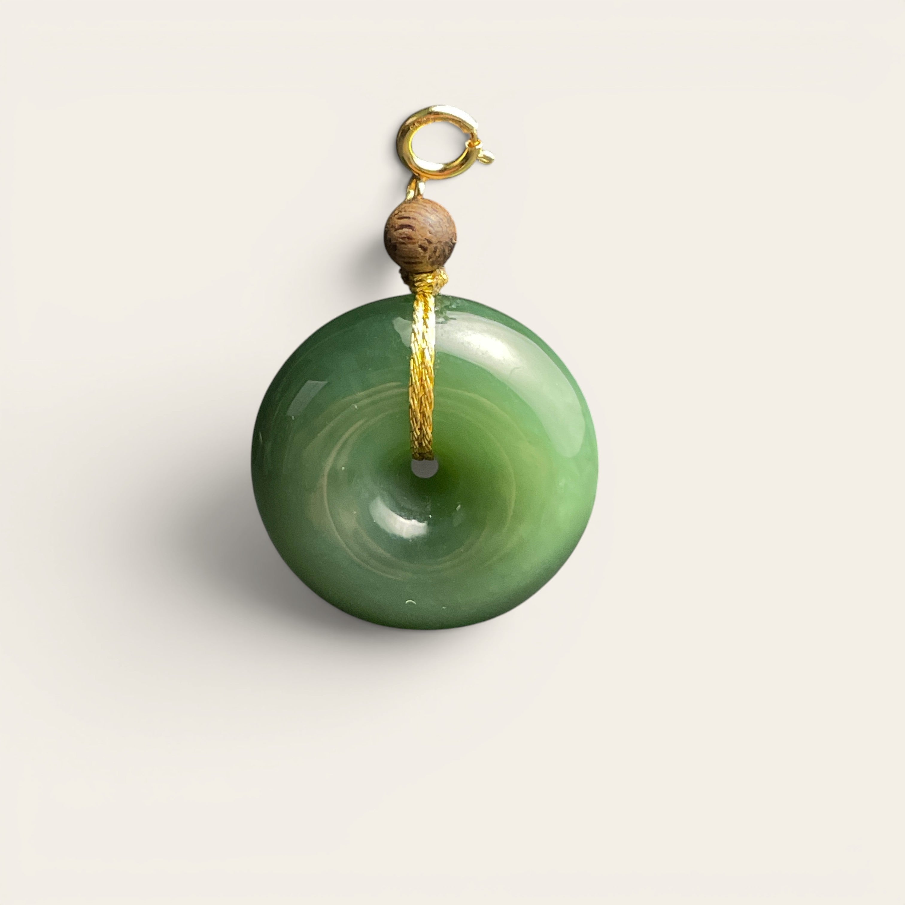 Sylvia Jewelry green jade donut pendant with a gold clasp and small wooden bead accent