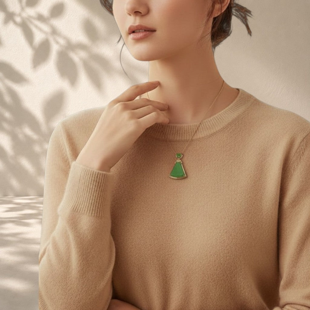 Sylvia Jewelry green jade pendant necklace in a triangular shape worn by a woman in a beige sweater.