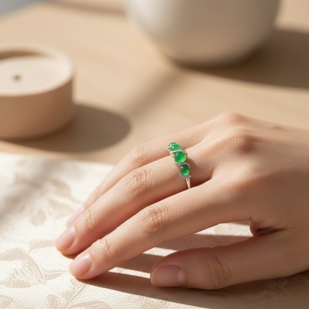 Sylvia Jewelry ring featuring three round green jade cabochons set in a delicate silver band on a woman's hand.