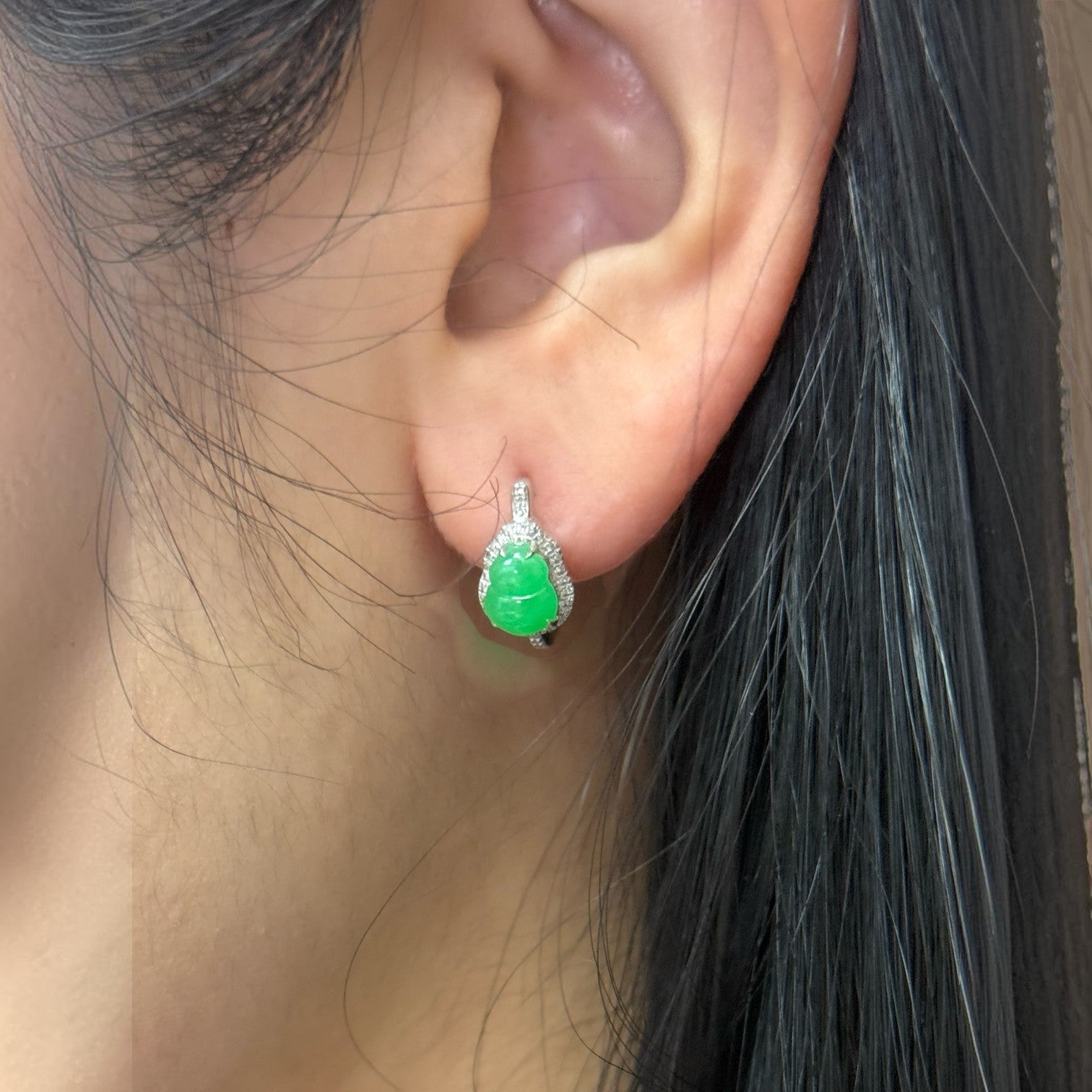 Sylvia Jewelry apple green jadeite Hulu ear huggie earrings in 18k white gold with micro-pavé diamonds on an ear.
