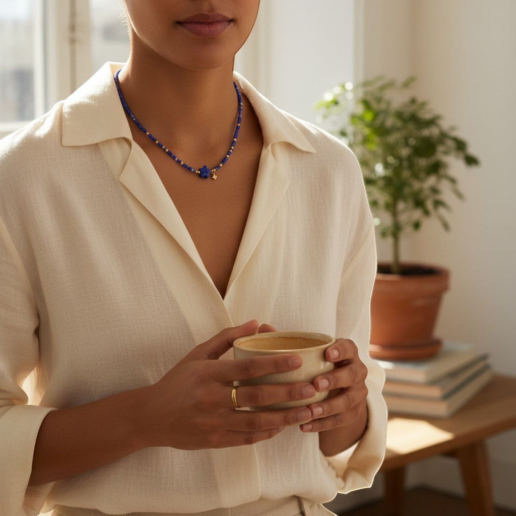 Sylvia Jewelry Celestial Night lapis lazuli beaded choker with gold-plated star charm worn by a woman in white linen