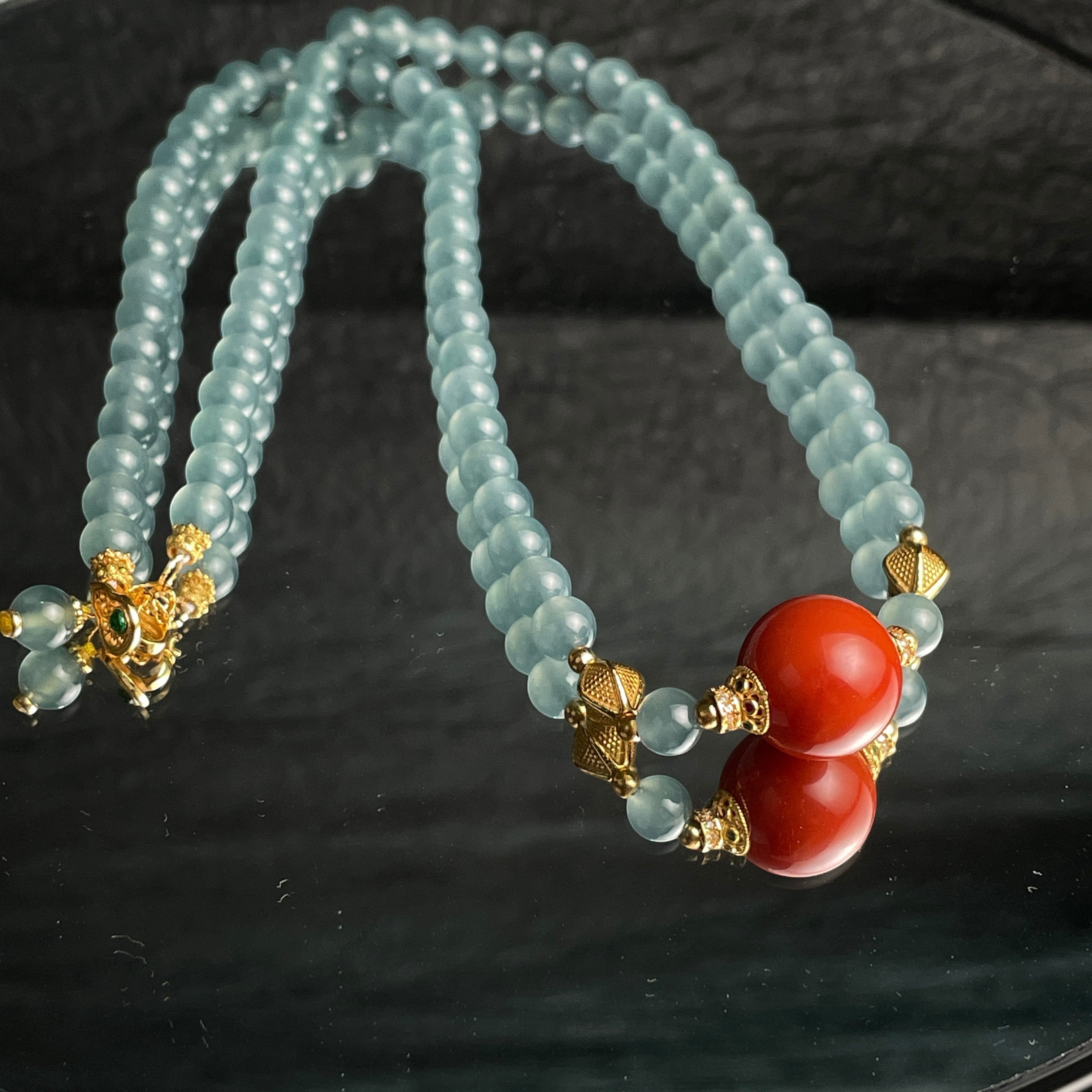 Sylvia Jewelry 浅蓝色珠子项链，带有两个红色珊瑚珠和金色配件，适合日常佩戴。