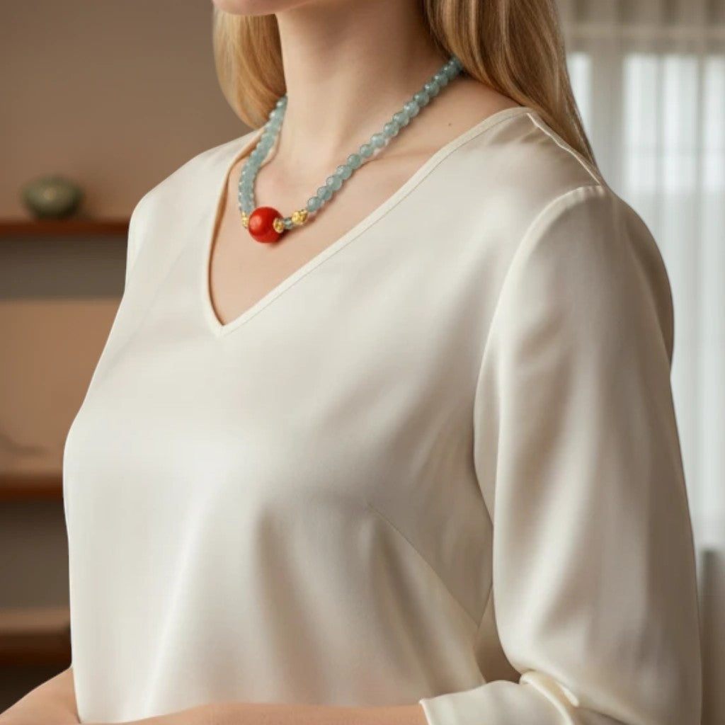 Sylvia Jewelry 浅蓝色串珠项链，配有红色圆形吊坠和金色细节。