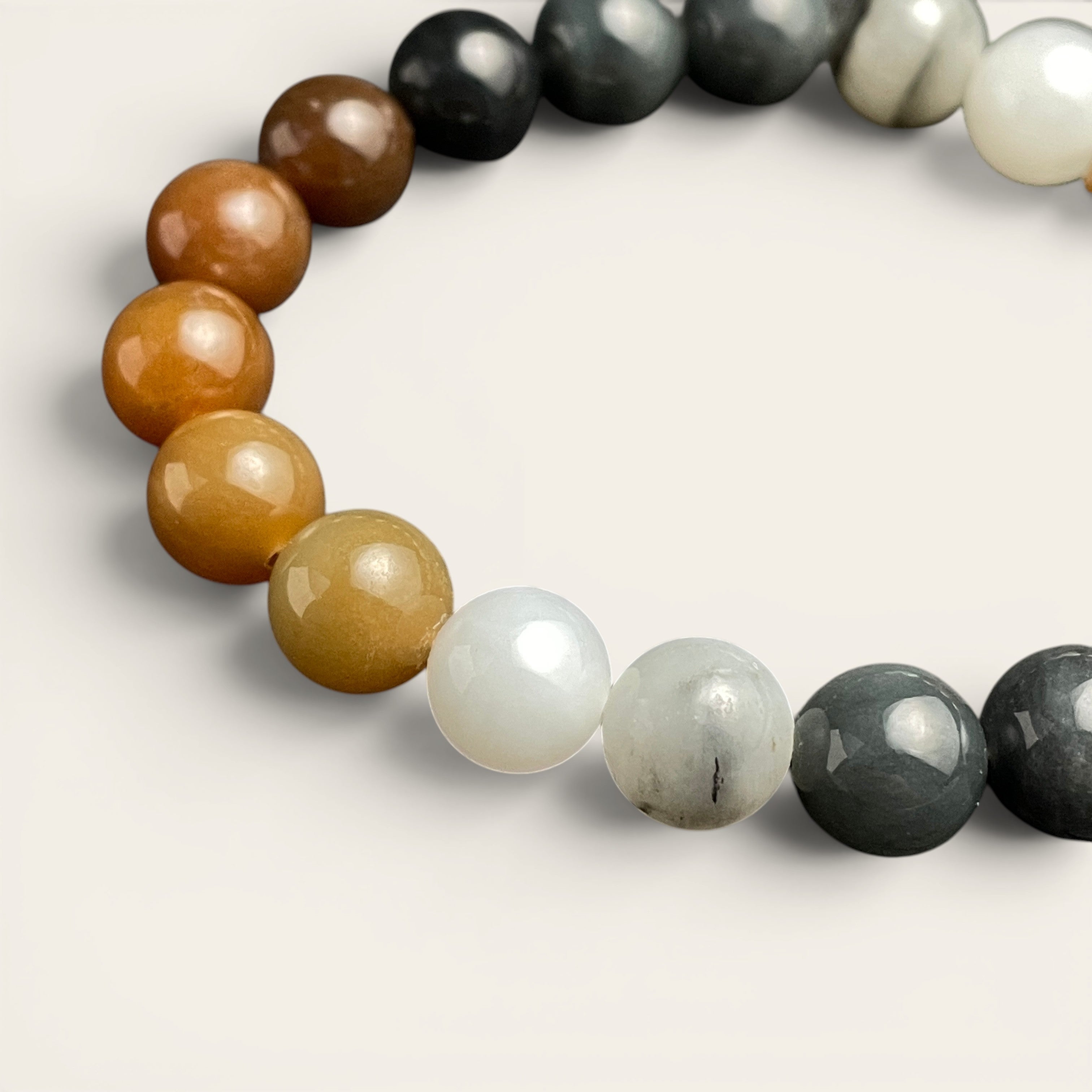 Sylvia Jewelry multi-colored Hetian nephrite jade bead bracelet featuring a gradient of amber, white, and ink-black stones.